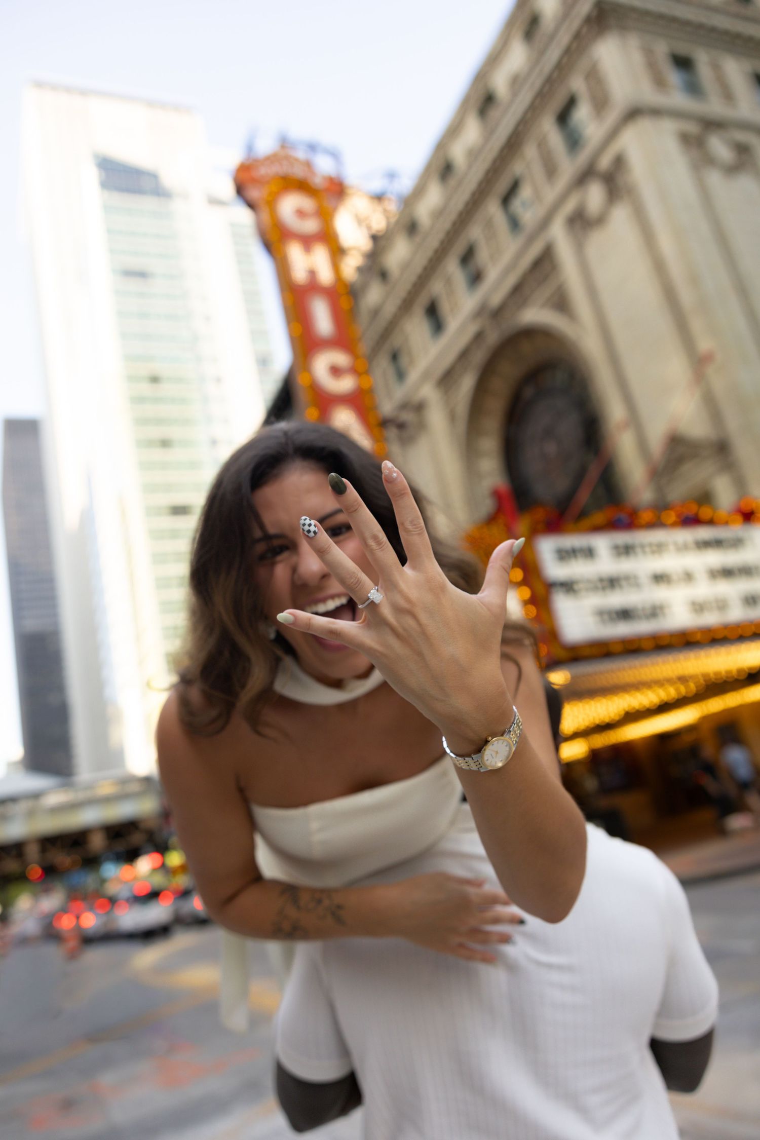 Joyful dance moves captured outside historic Chicago Theatre with glowing signage.