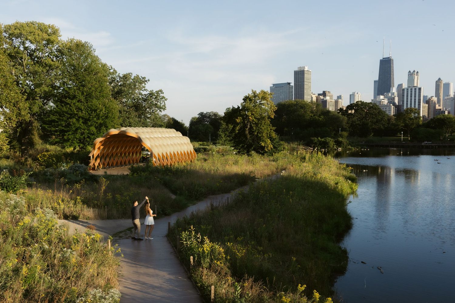 Urban trail winds along Lady Bird Lake with downtown Austin skyline and tranquil water views on a sunny day.