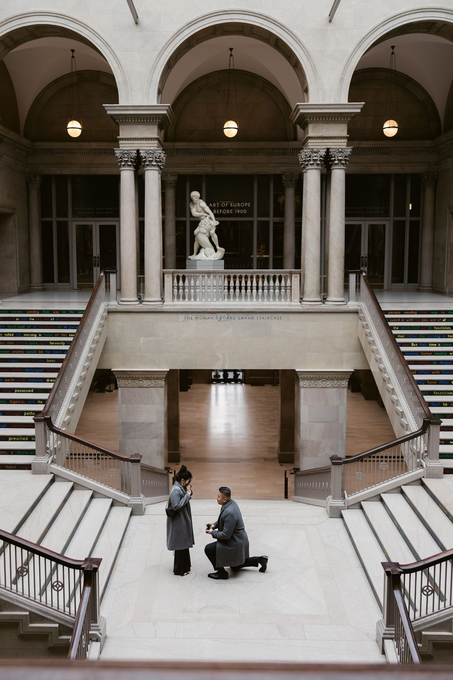 A proposal moment captured in a classical museum hall with arched columns and marble floors.