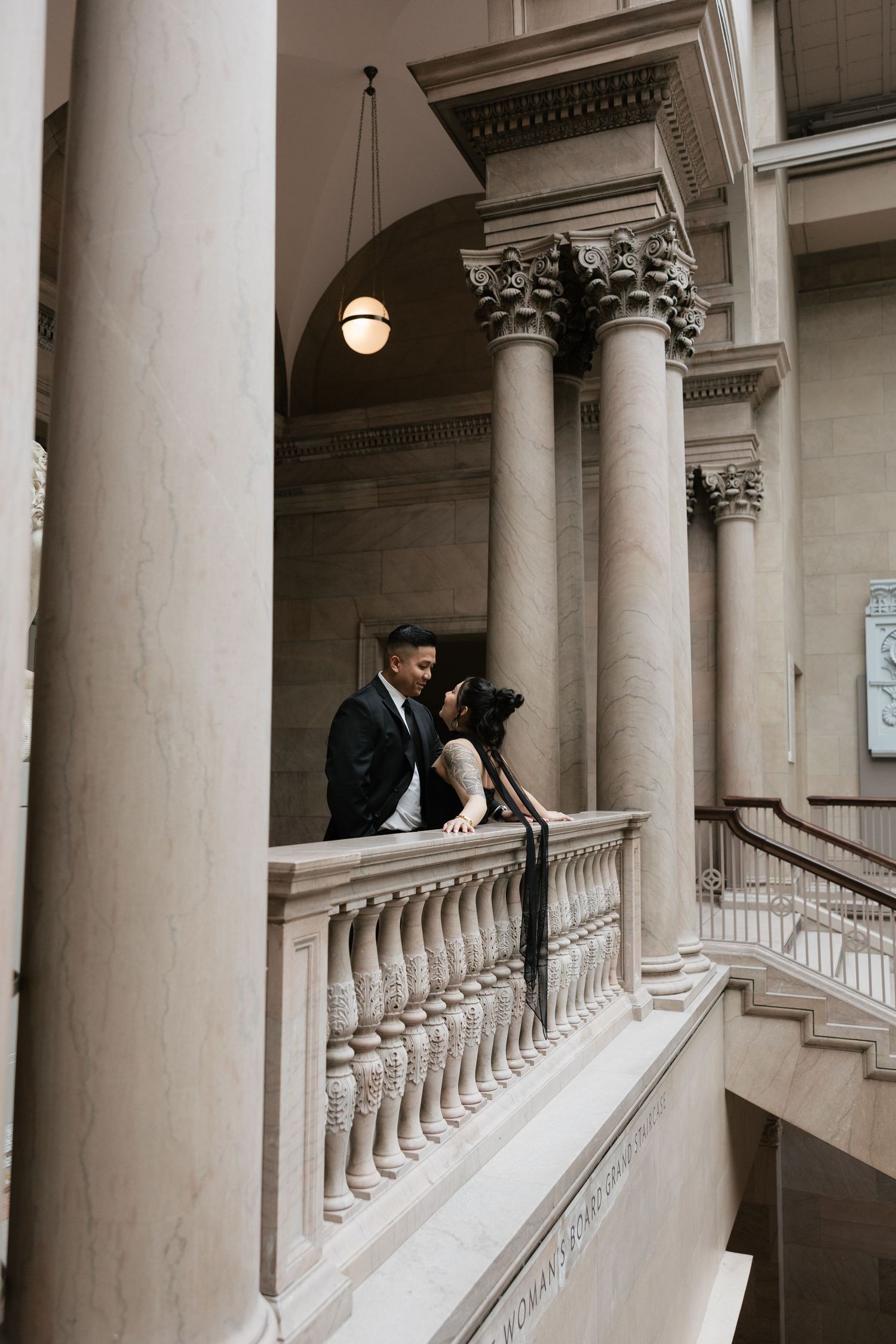 Classical architecture interior with white columns and ornate balustrades in a museum setting.