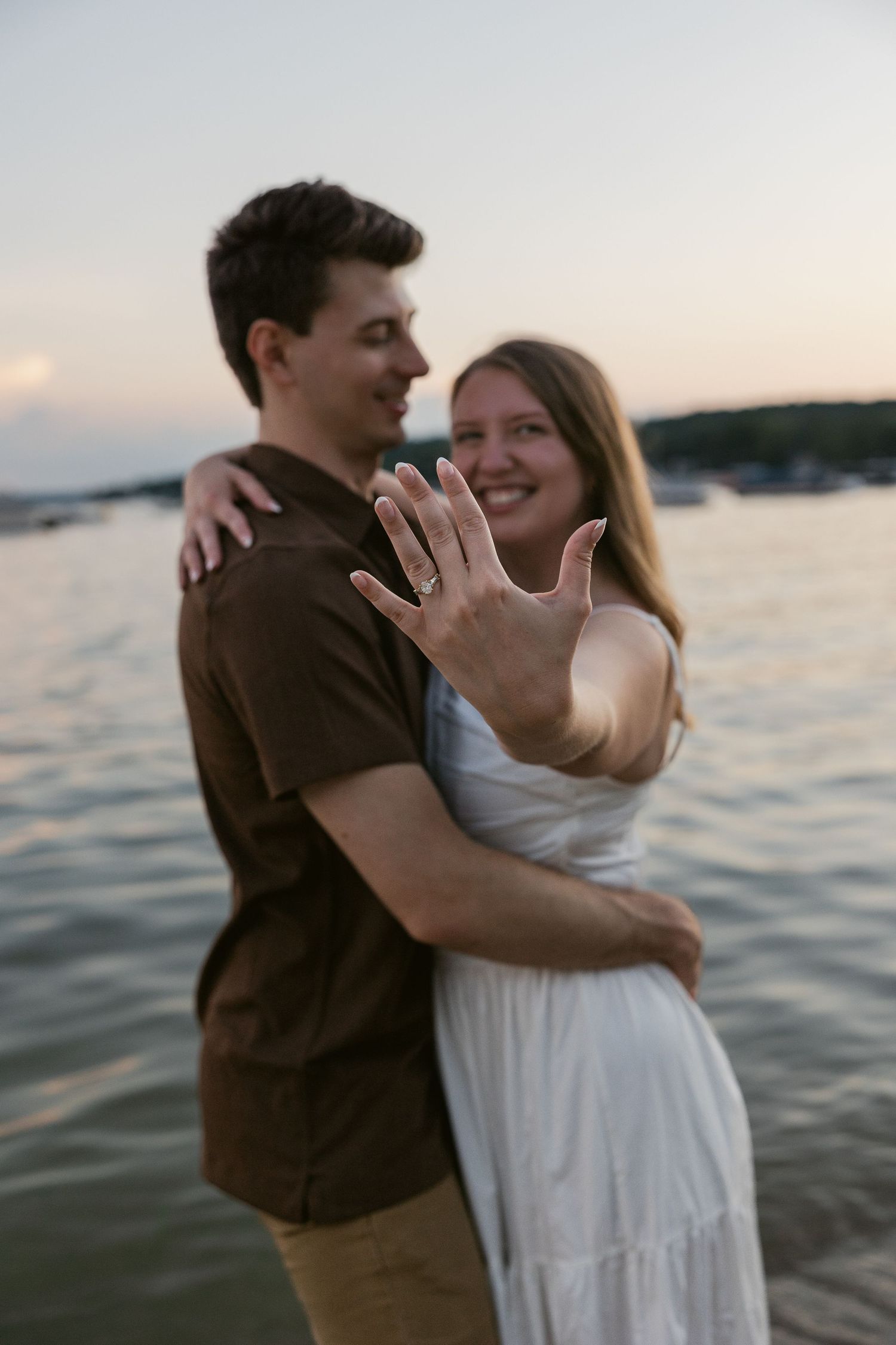 Romantic embrace captured during sunset photoshoot by the water.