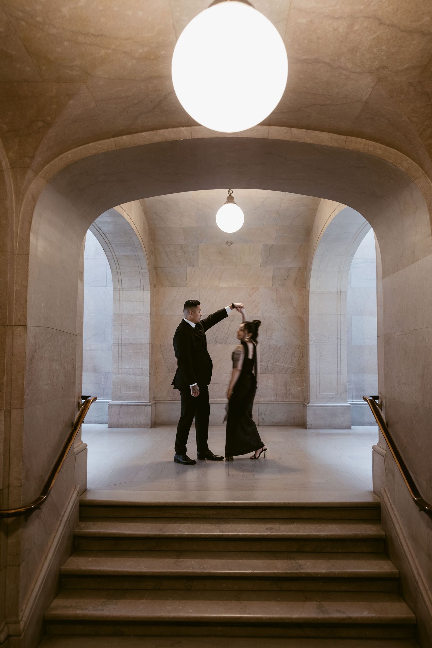 Silhouetted figures pose dramatically under arched ceilings with circular lighting.