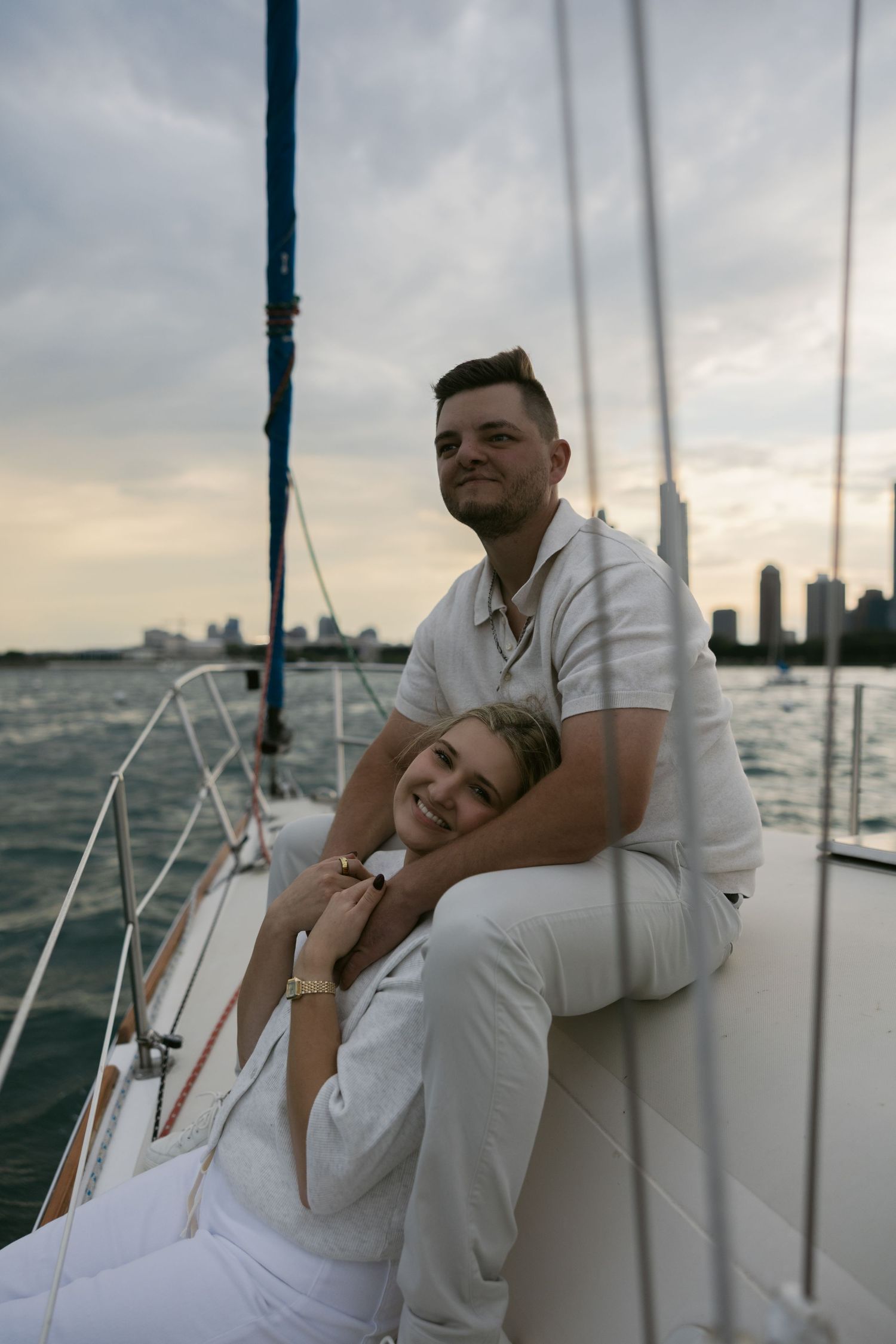 Intimate sailing moment captured with city skyline at dusk.