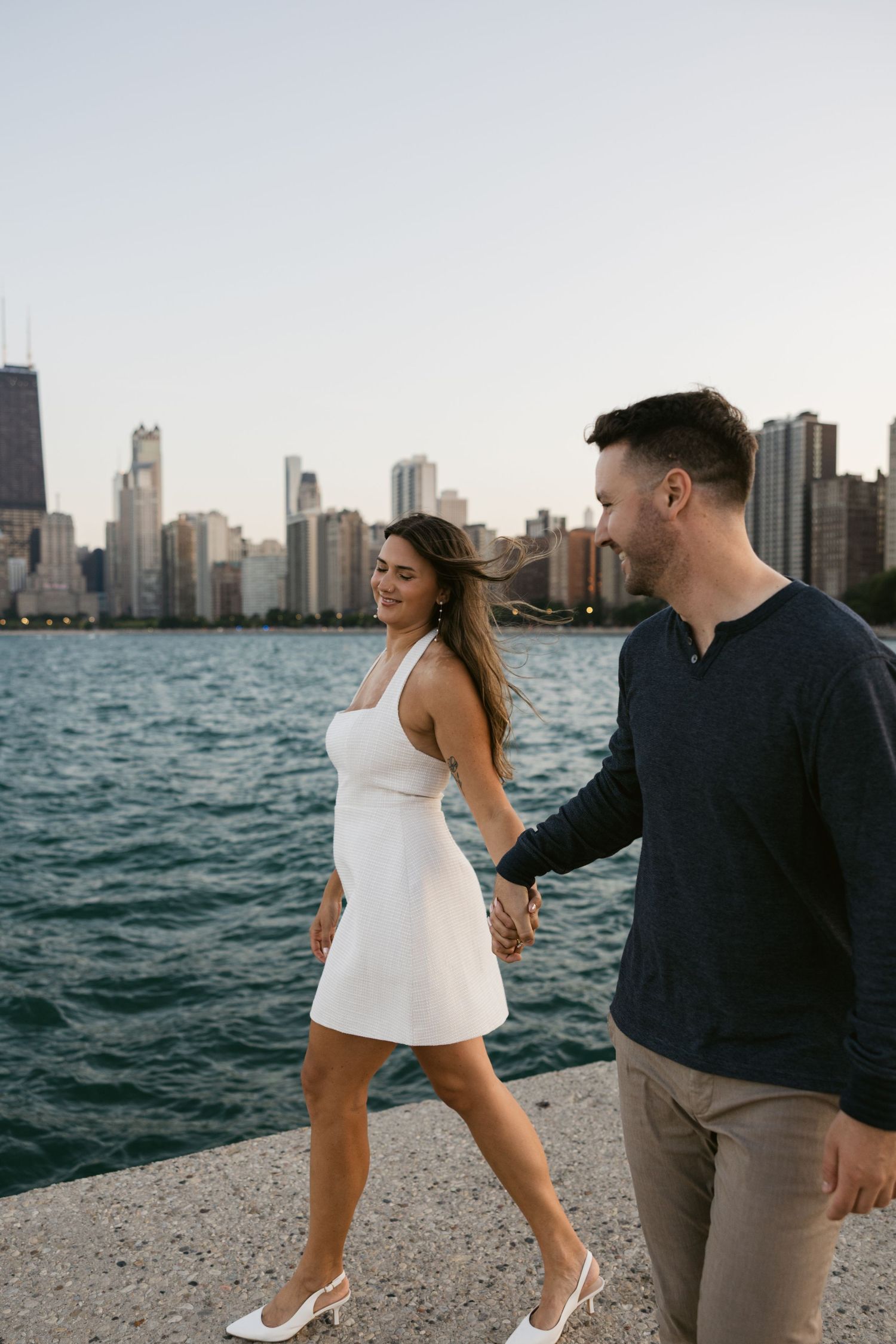 Couple enjoying moment together along Chicago waterfront with iconic skyline view.