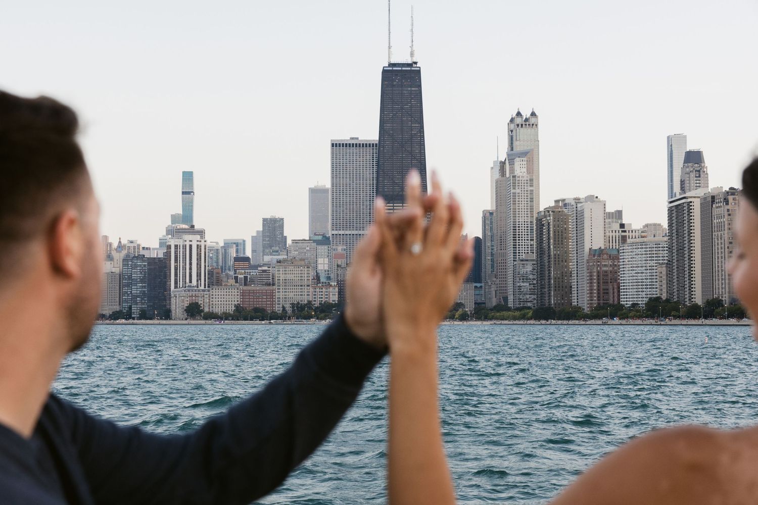 Panoramic view of Chicago skyline with people walking along the waterfront.