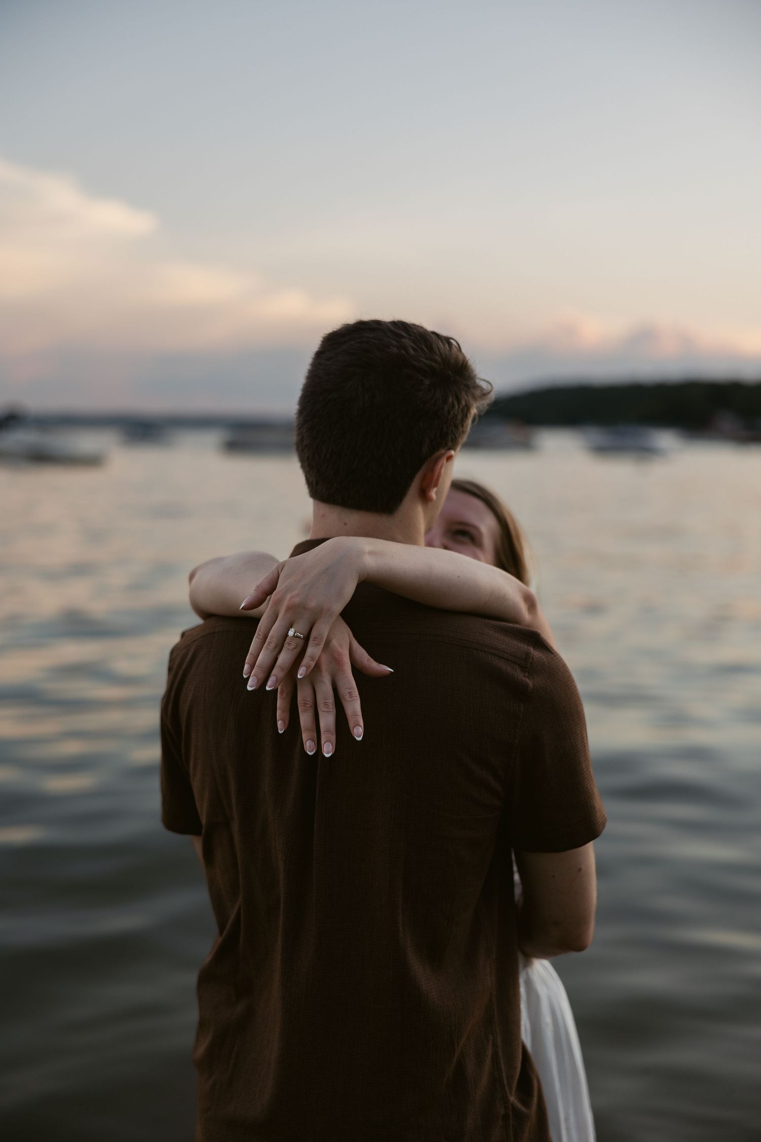 A tender embrace captured in silhouette against the evening water.