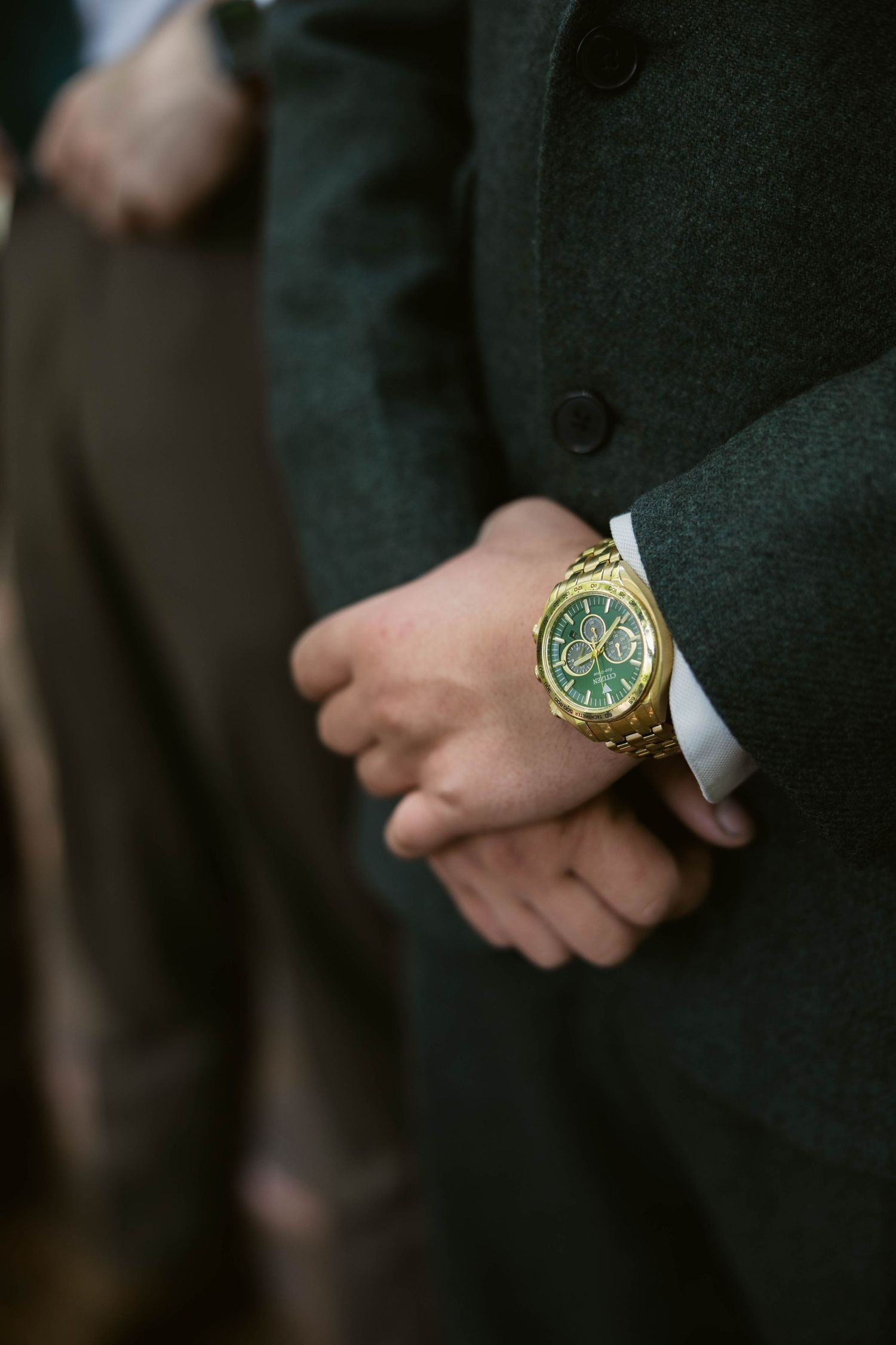 Close-up of gold watch detail on formal attire.