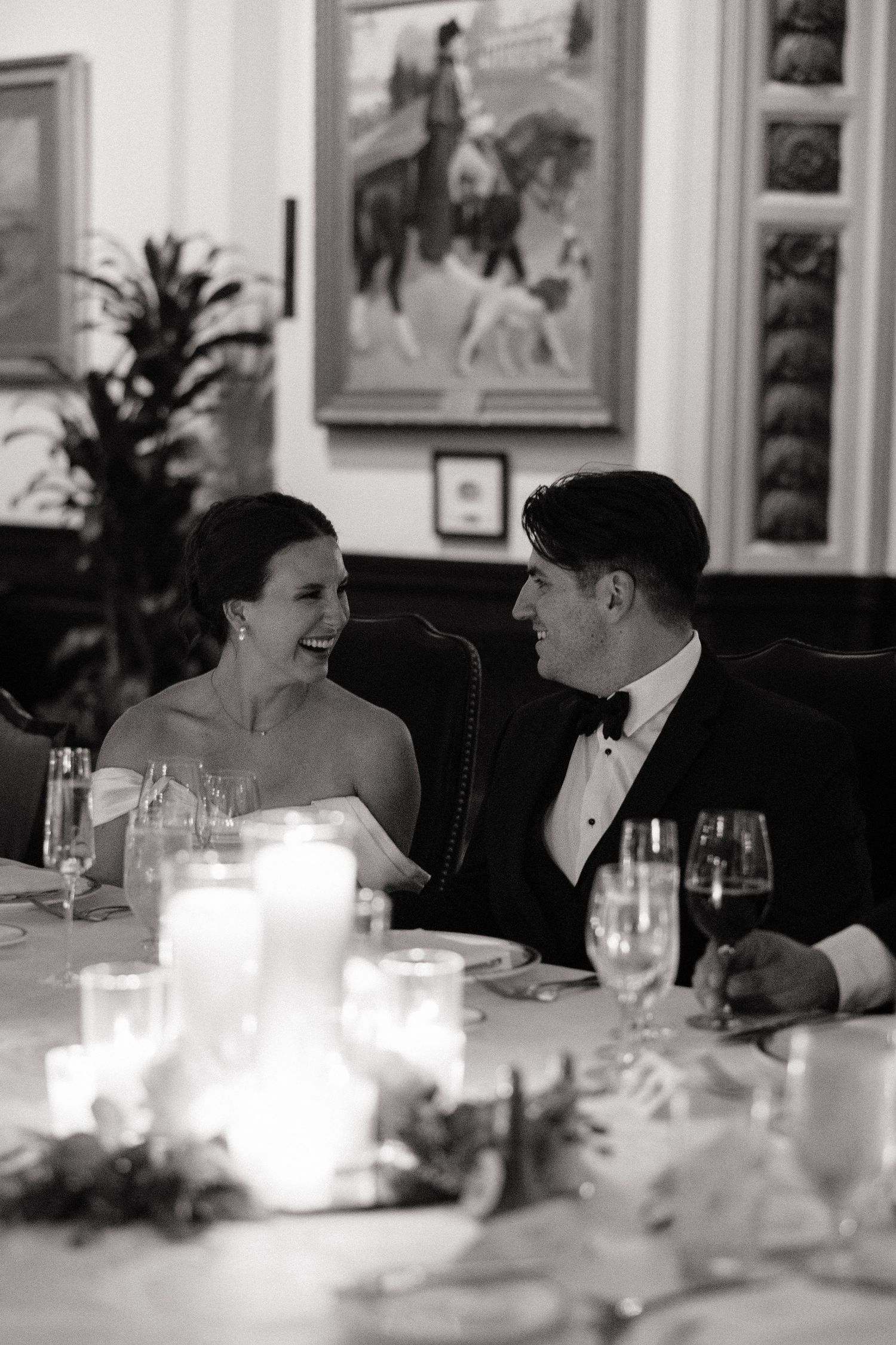 A romantic candlelit wedding reception dinner scene in black and white.
