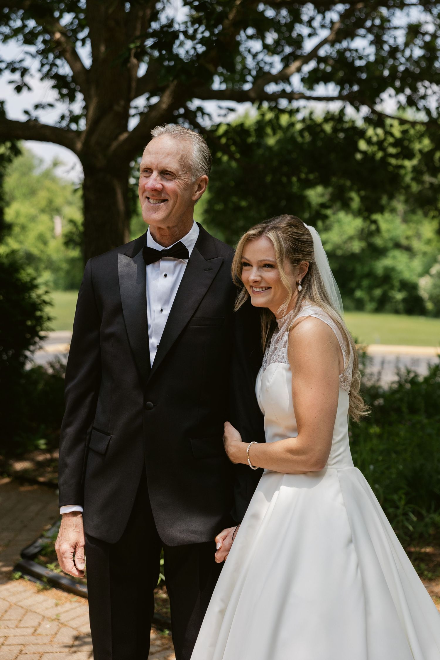 A couple shares a happy moment together during their wedding day in a garden setting.