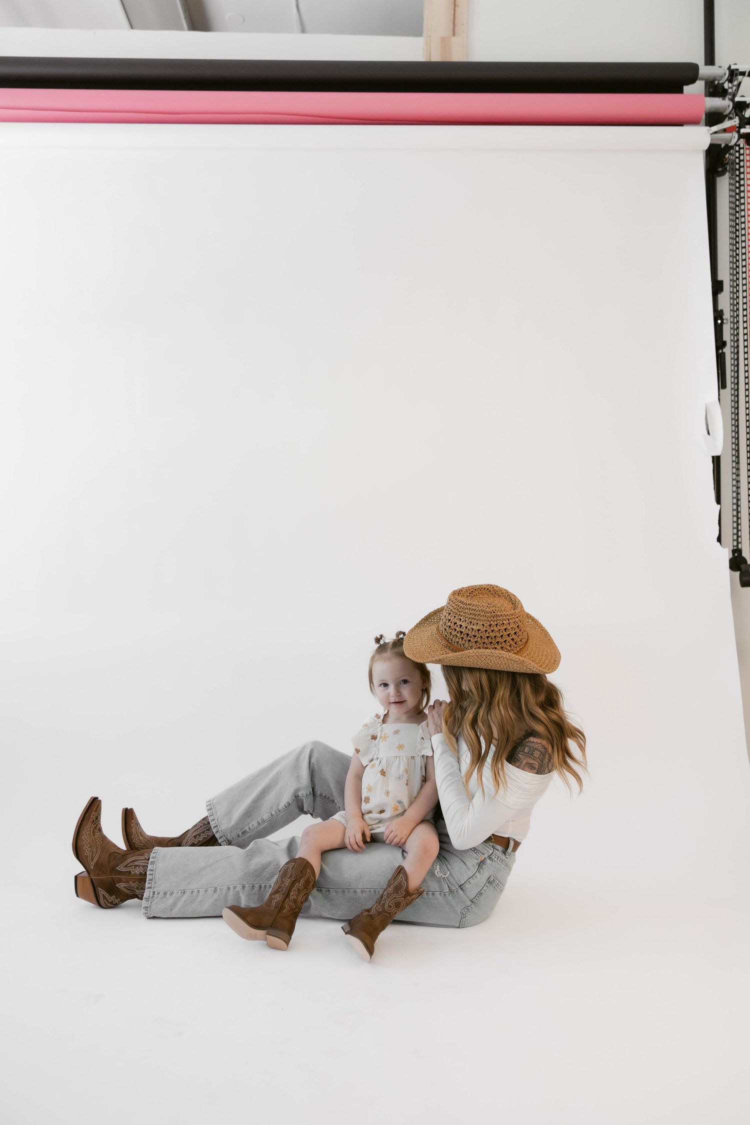 Casual lifestyle portrait session on white background features relaxed poses in denim and boots.