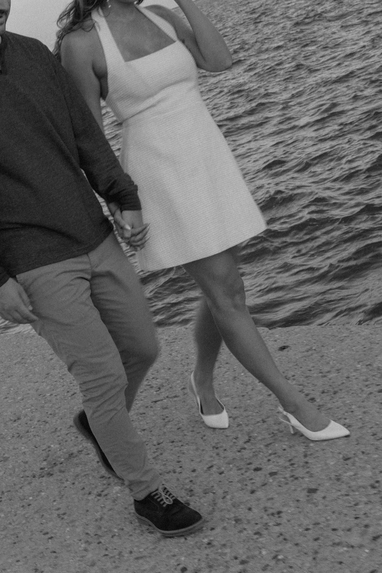 Close-up of feet and legs during a couple's photoshoot by the water.