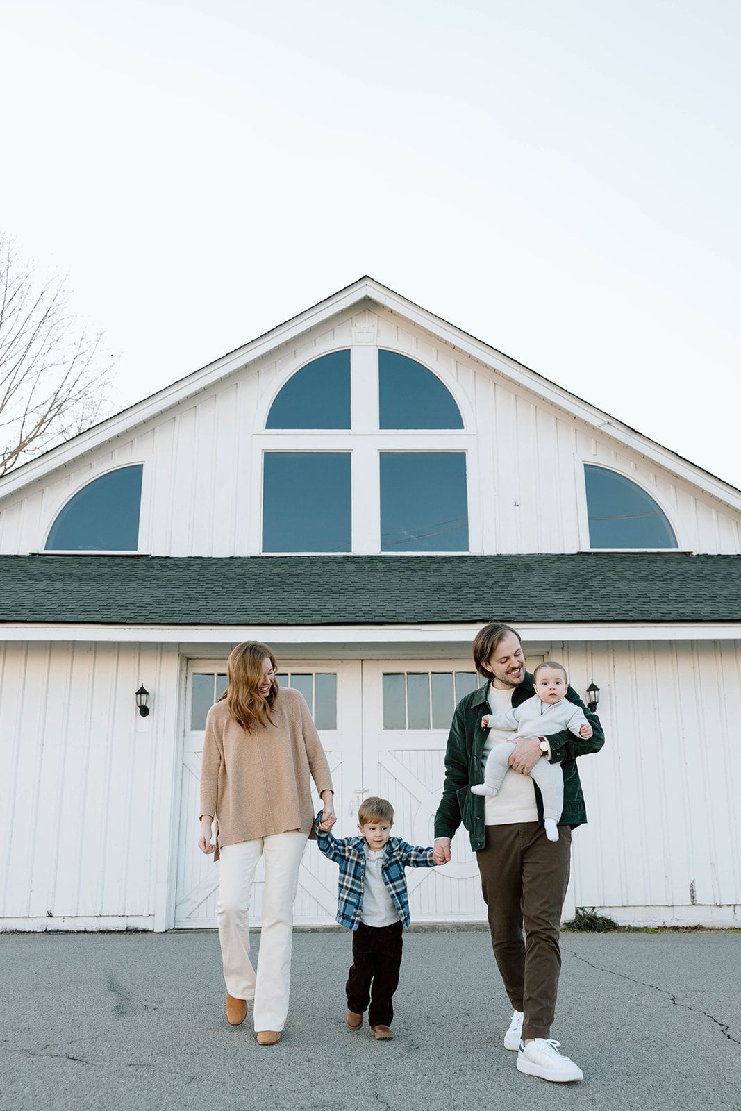 FAMILY CANDID PHOTO IN FRONT OF A WHITE BARN