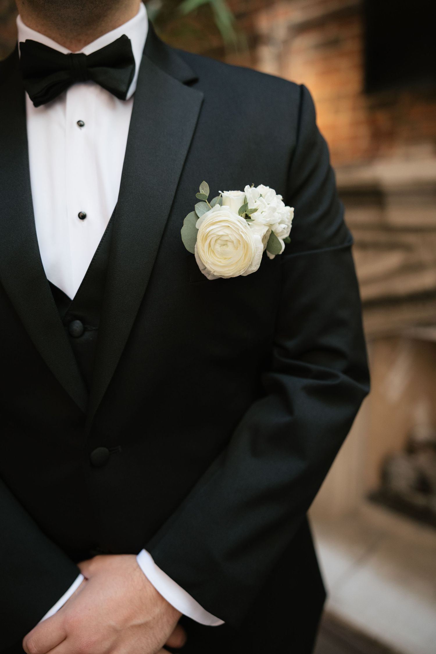 Close up of a classic black tuxedo with white rose boutonniere.