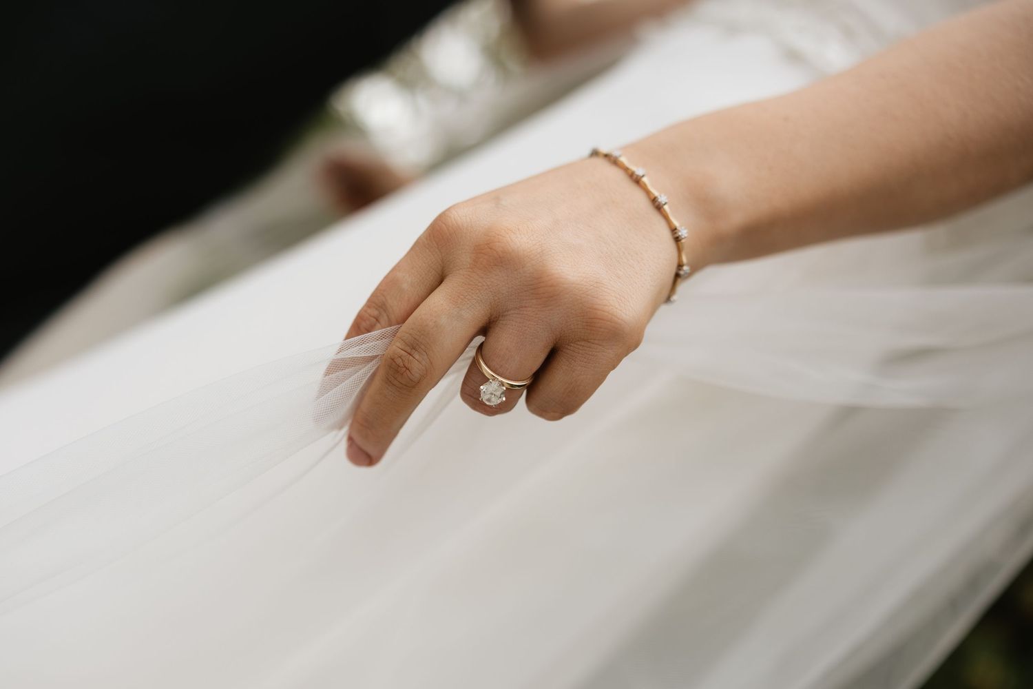 Close-up shots of bride's hand showing delicate wedding ring and jewelry details.
