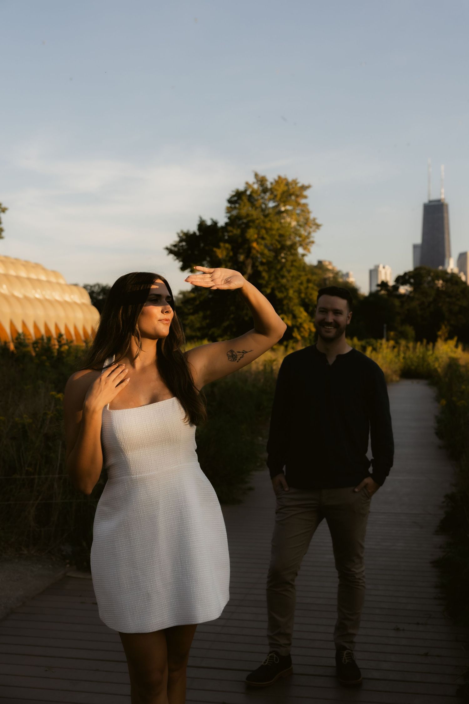 A couple shares playful moments in silhouette against the Chicago skyline at sunset.