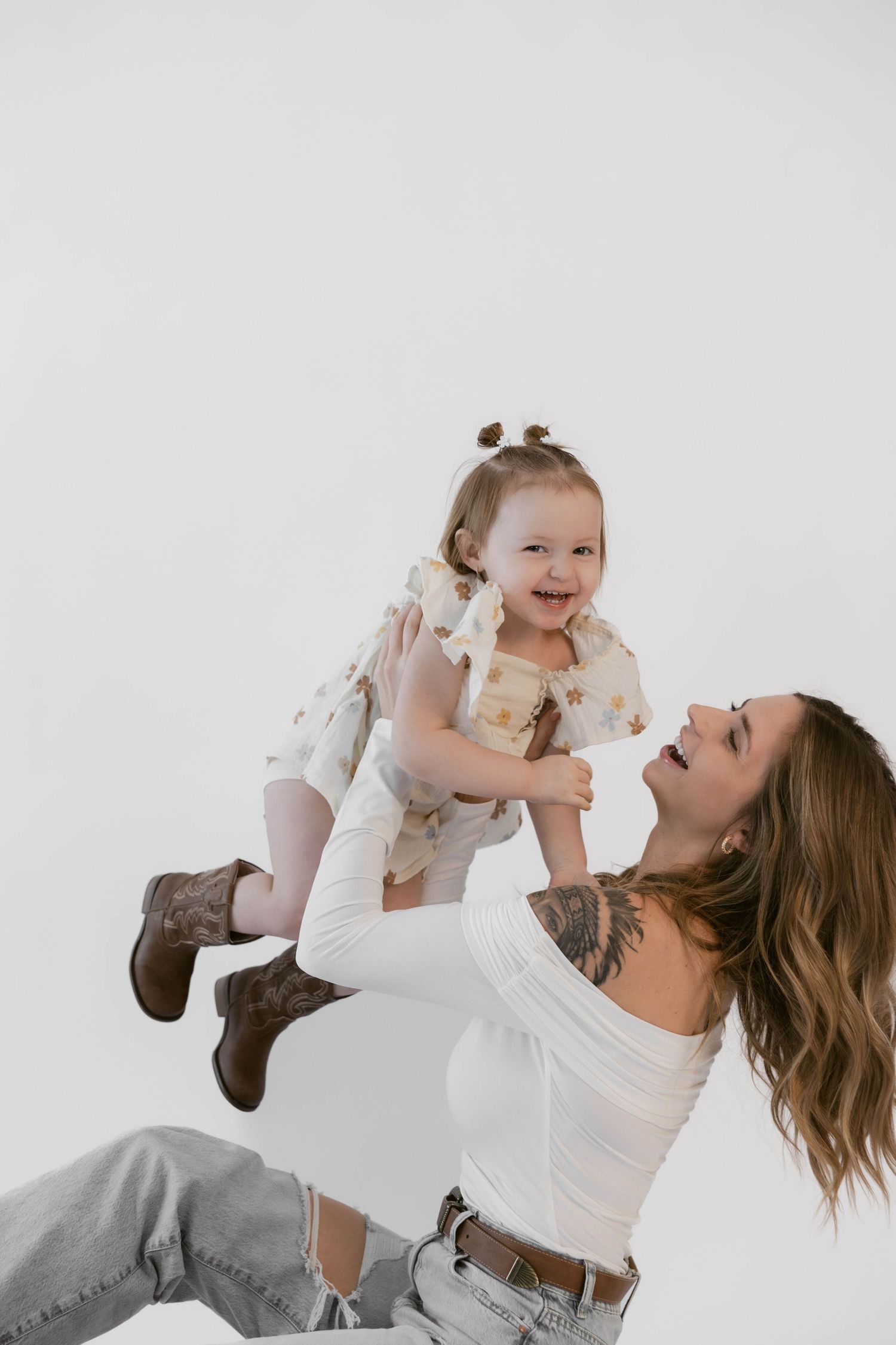 A candid moment of joy captured during white backdrop studio photography session.