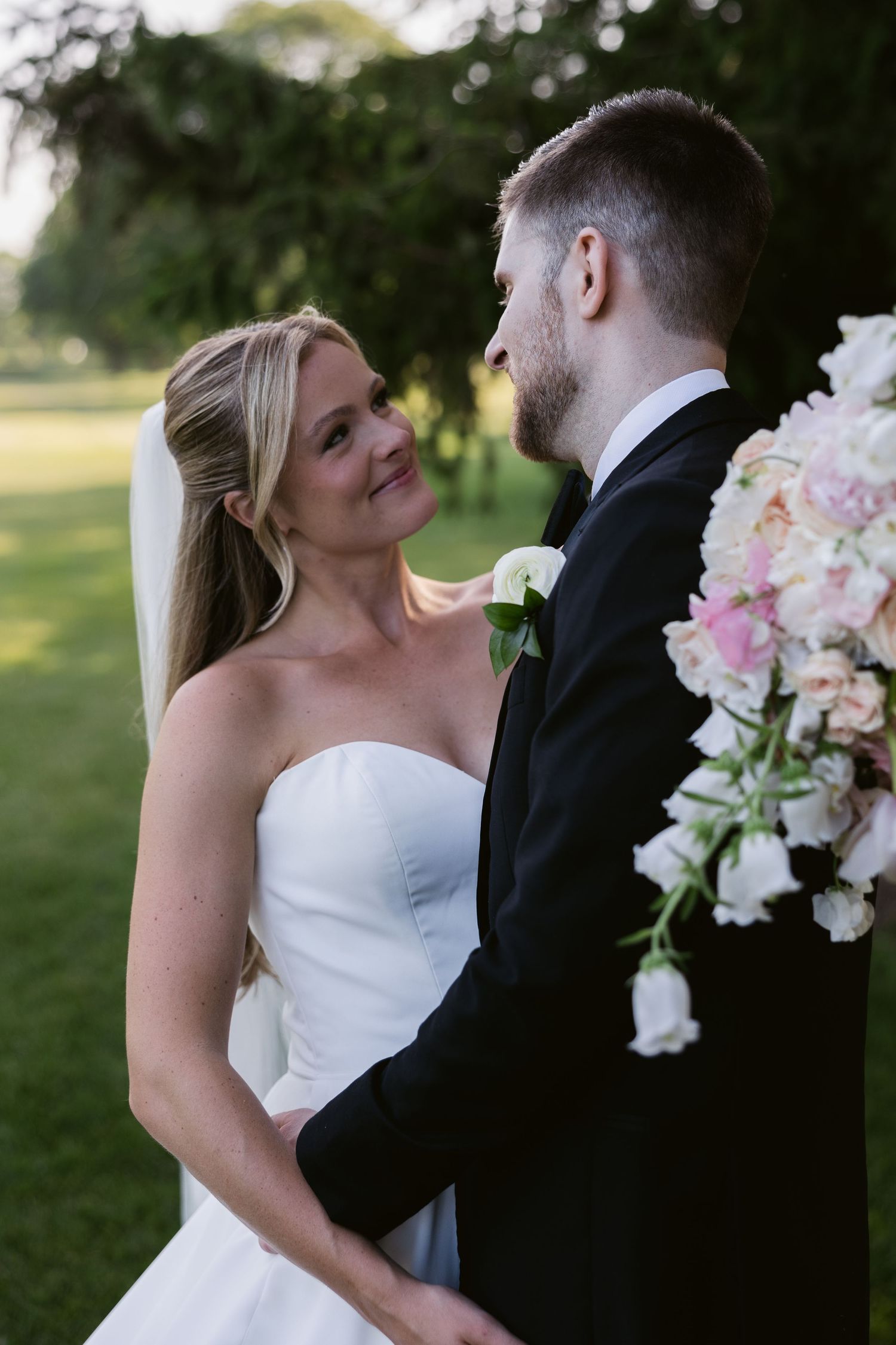 An elegant wedding portrait set against lush greenery with beautiful floral arrangements.