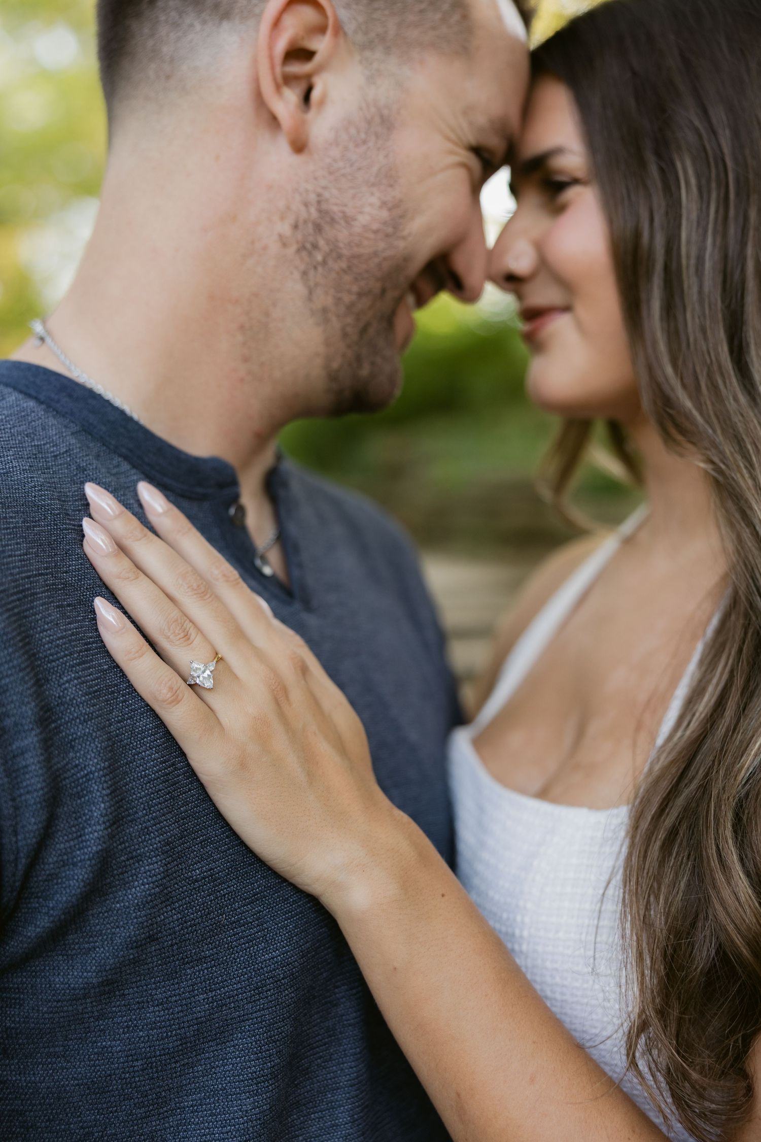 Close up engagement photos showing a couple in an intimate moment with a sparkly diamond ring visible.