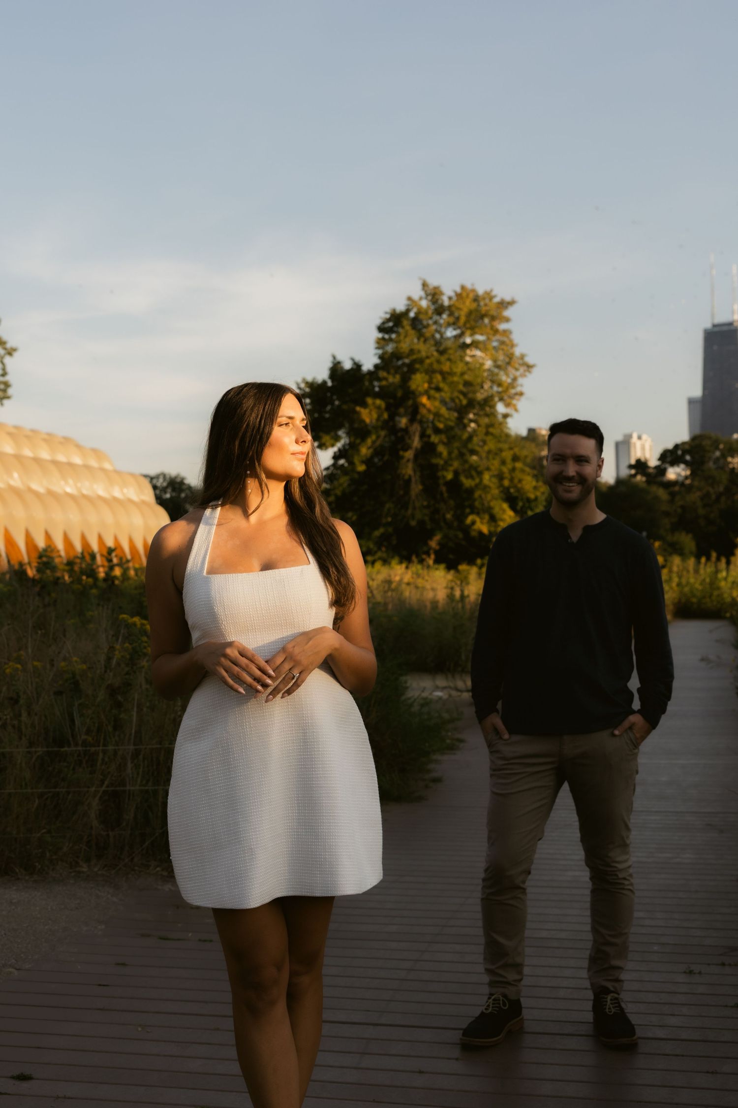 A scenic boardwalk path at sunset with natural vegetation and golden light creating a romantic atmosphere.