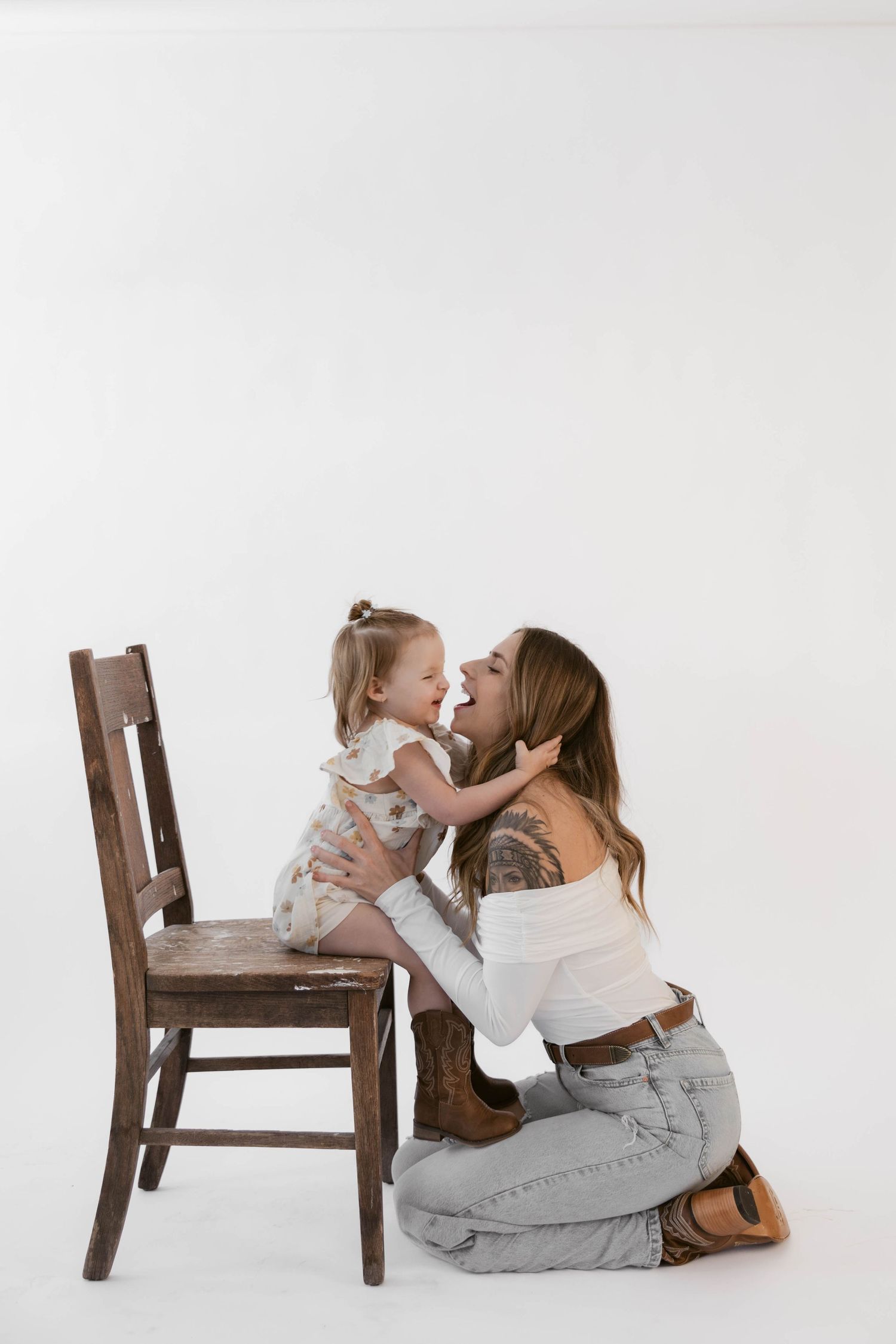 Joyful interaction captured in studio with wooden chair against white background.