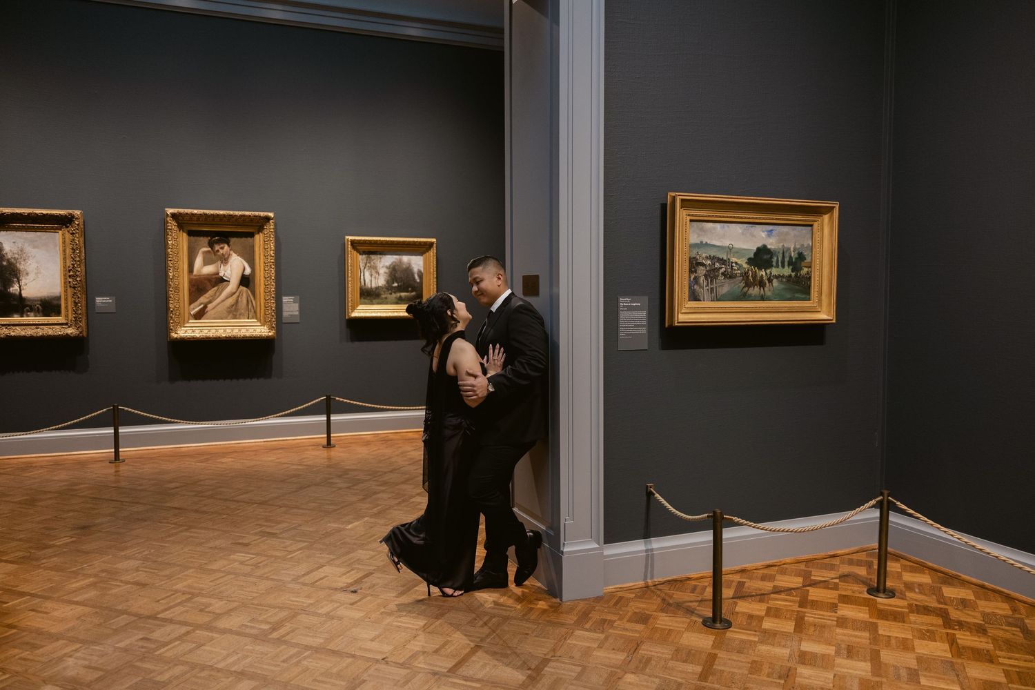 Museum gallery space with multiple framed artworks displayed on gray walls.