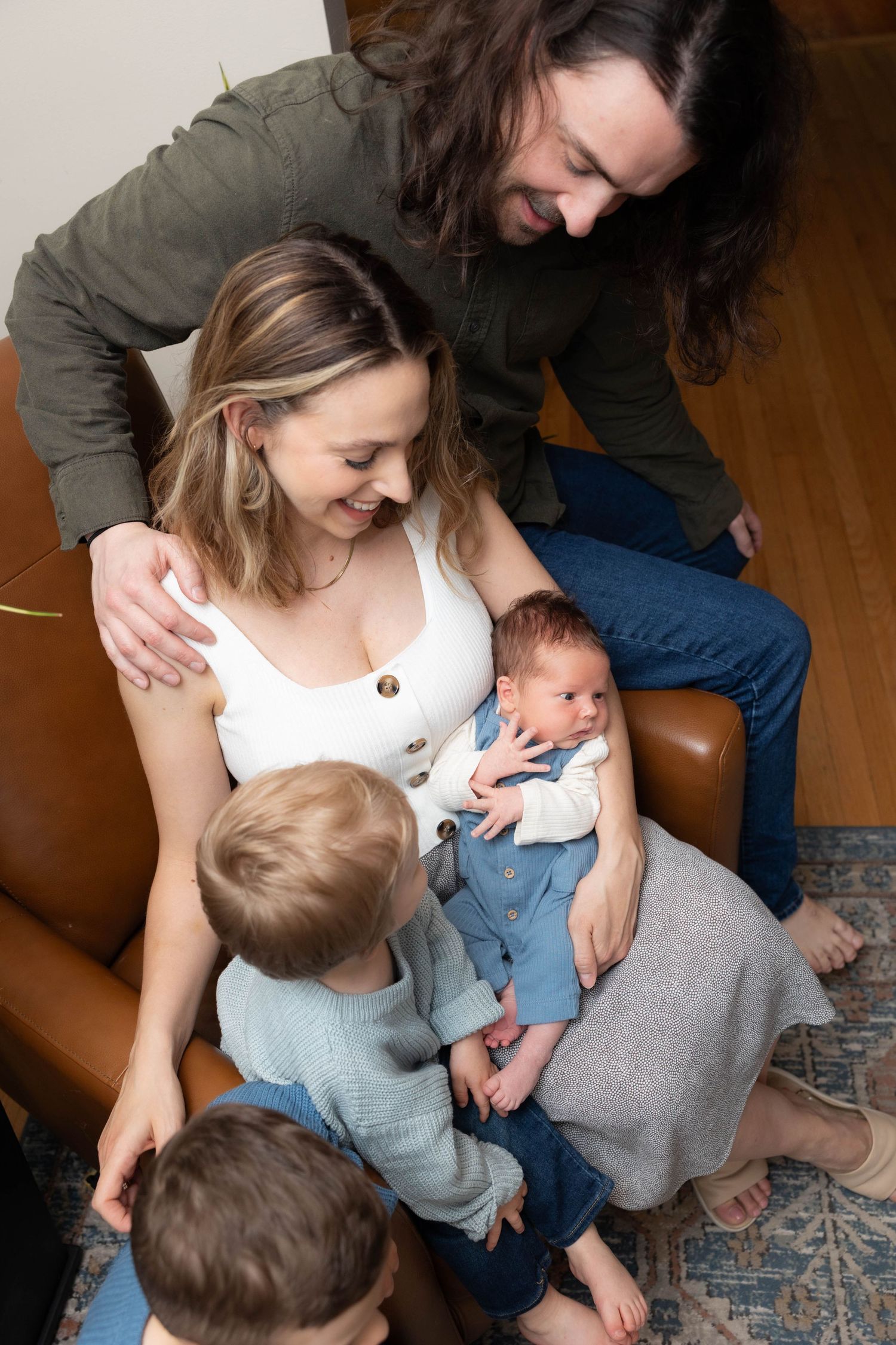 FAMILY PHOTOSHOOT LOOKING AT NEWBORN BABY