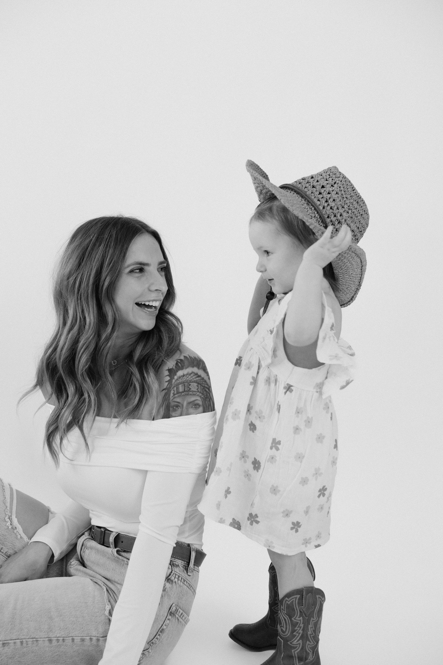 Mother and child sharing a laughing moment during black and white portrait session.