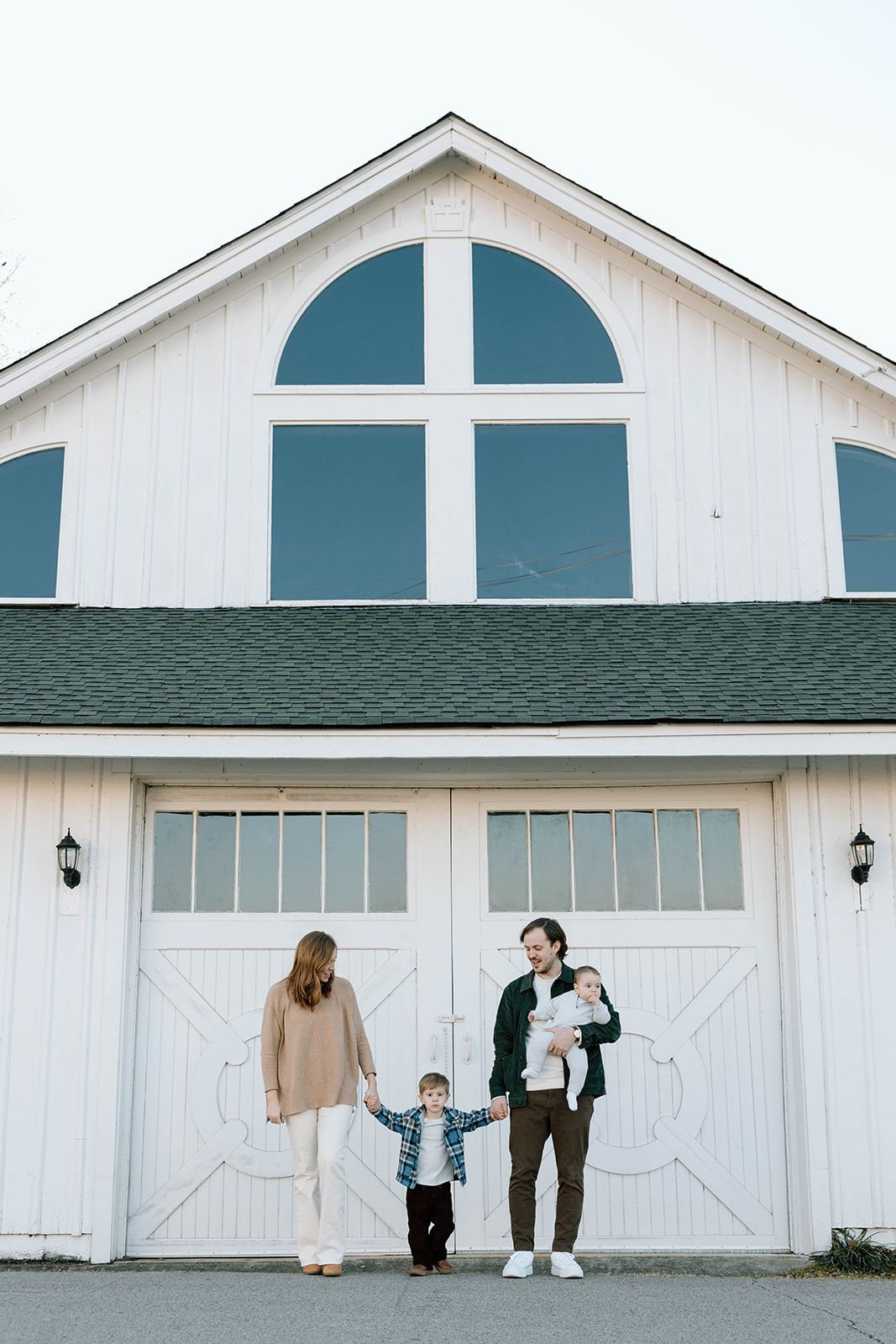 FAMILY CANDID PHOTO IN FRONT OF A WHITE BARN