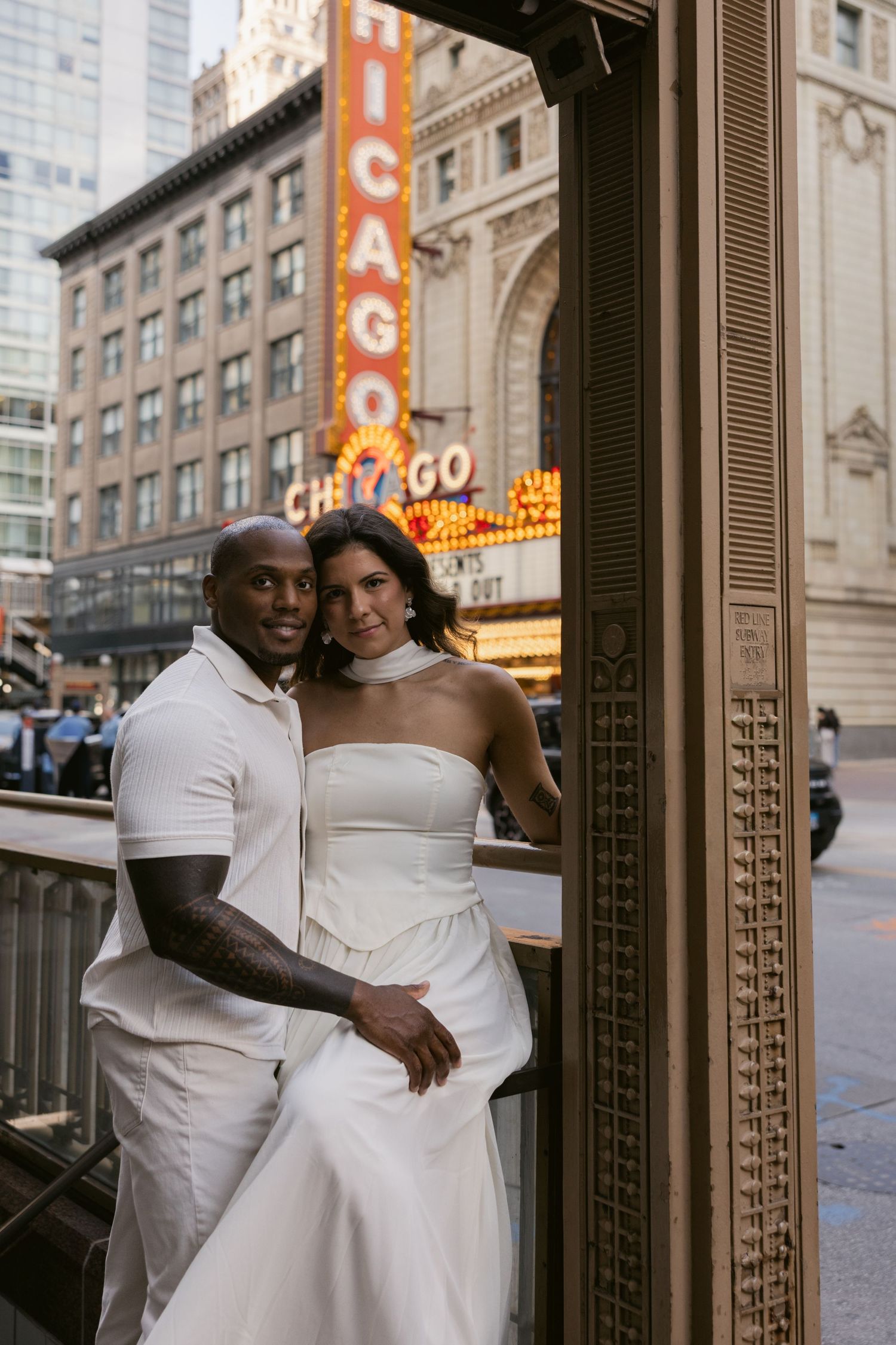 Couple embracing in front of historic Chicago theater entrance with ornate details.