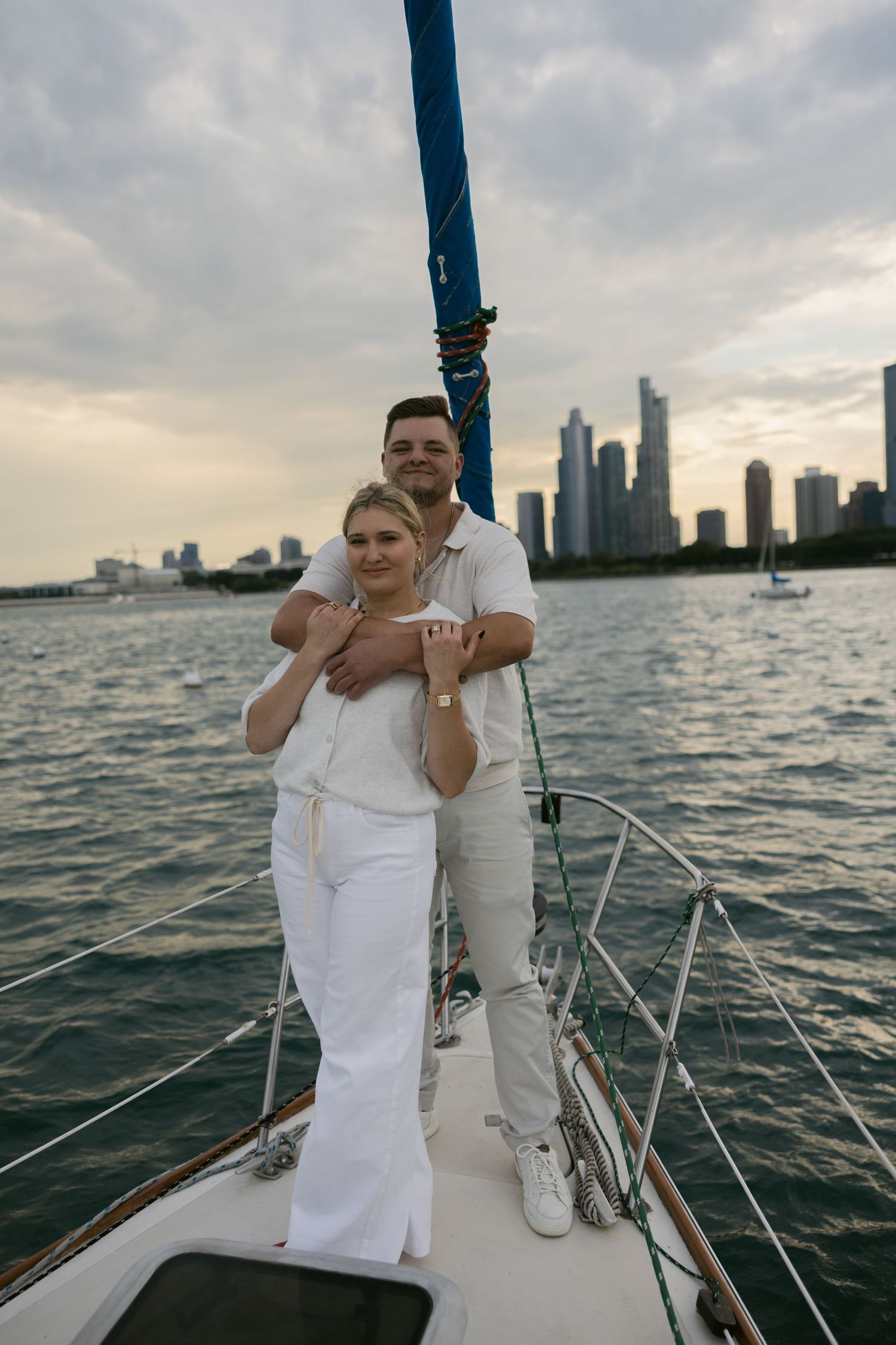 Couple in white outfits enjoying a romantic sail on Lake Michigan near Chicago's skyline.
