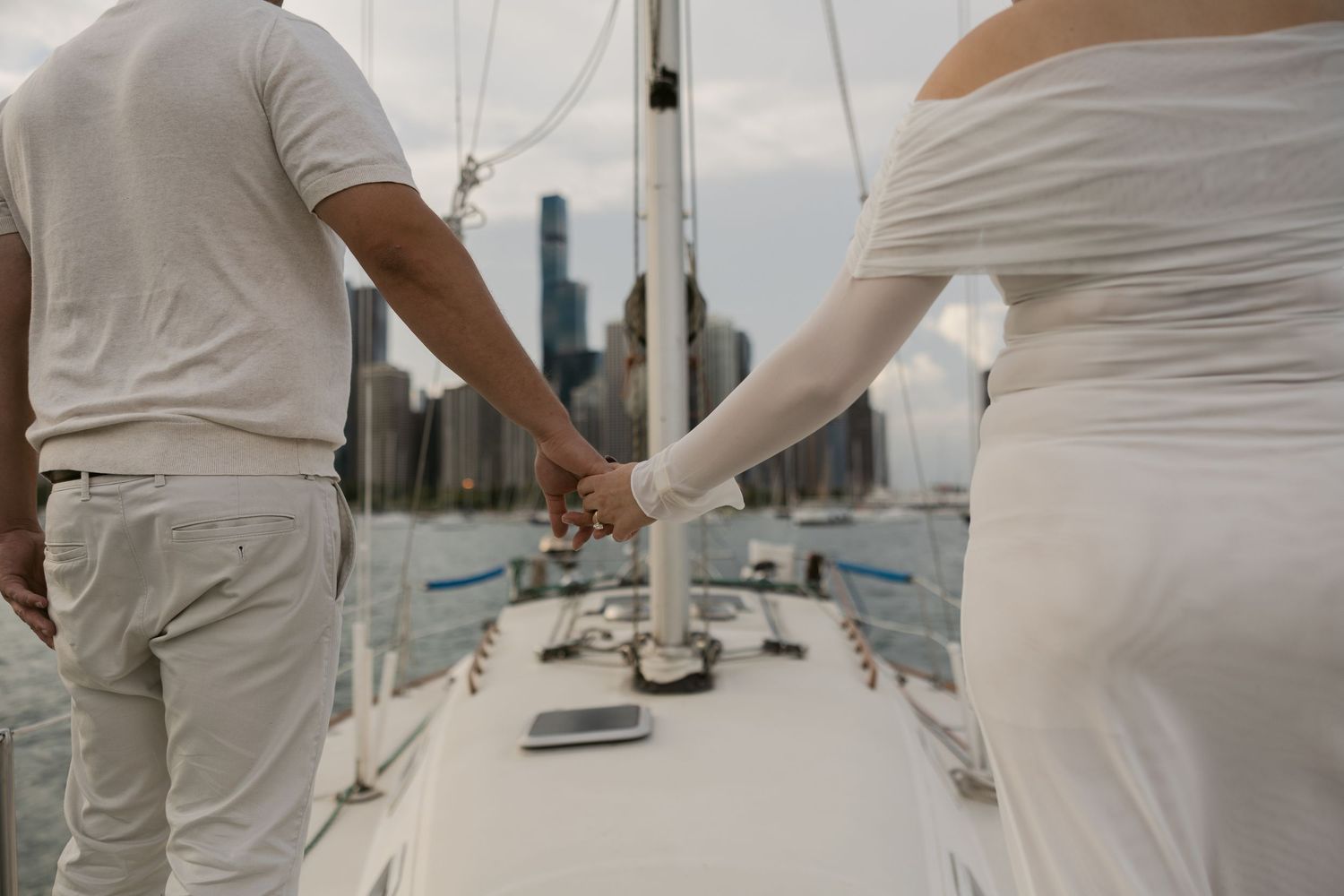 Two people dressed in white share an intimate moment while sailing on Lake Michigan near Chicago.