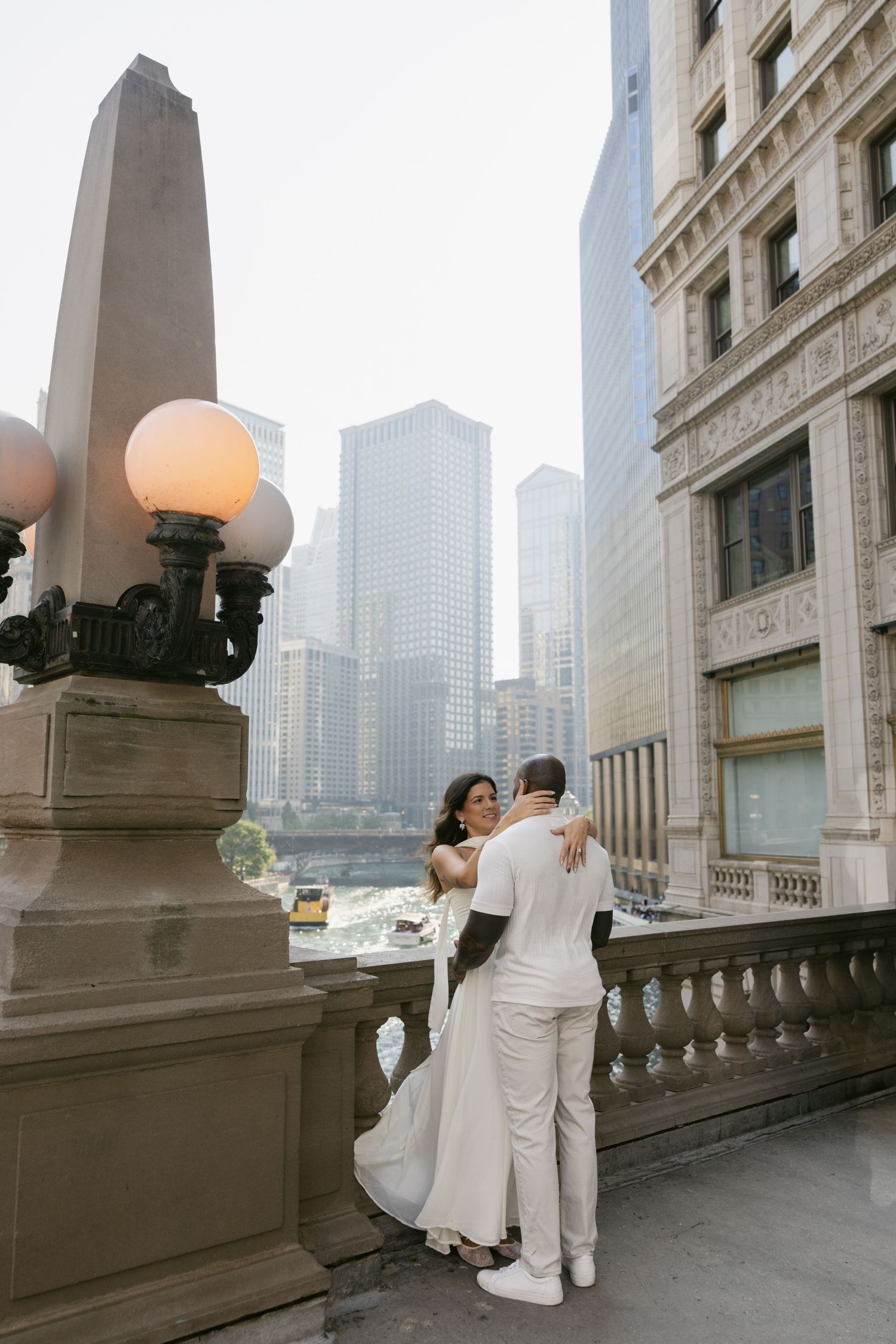 Wedding couple embracing on an urban balcony with Chicago city skyline in the background.