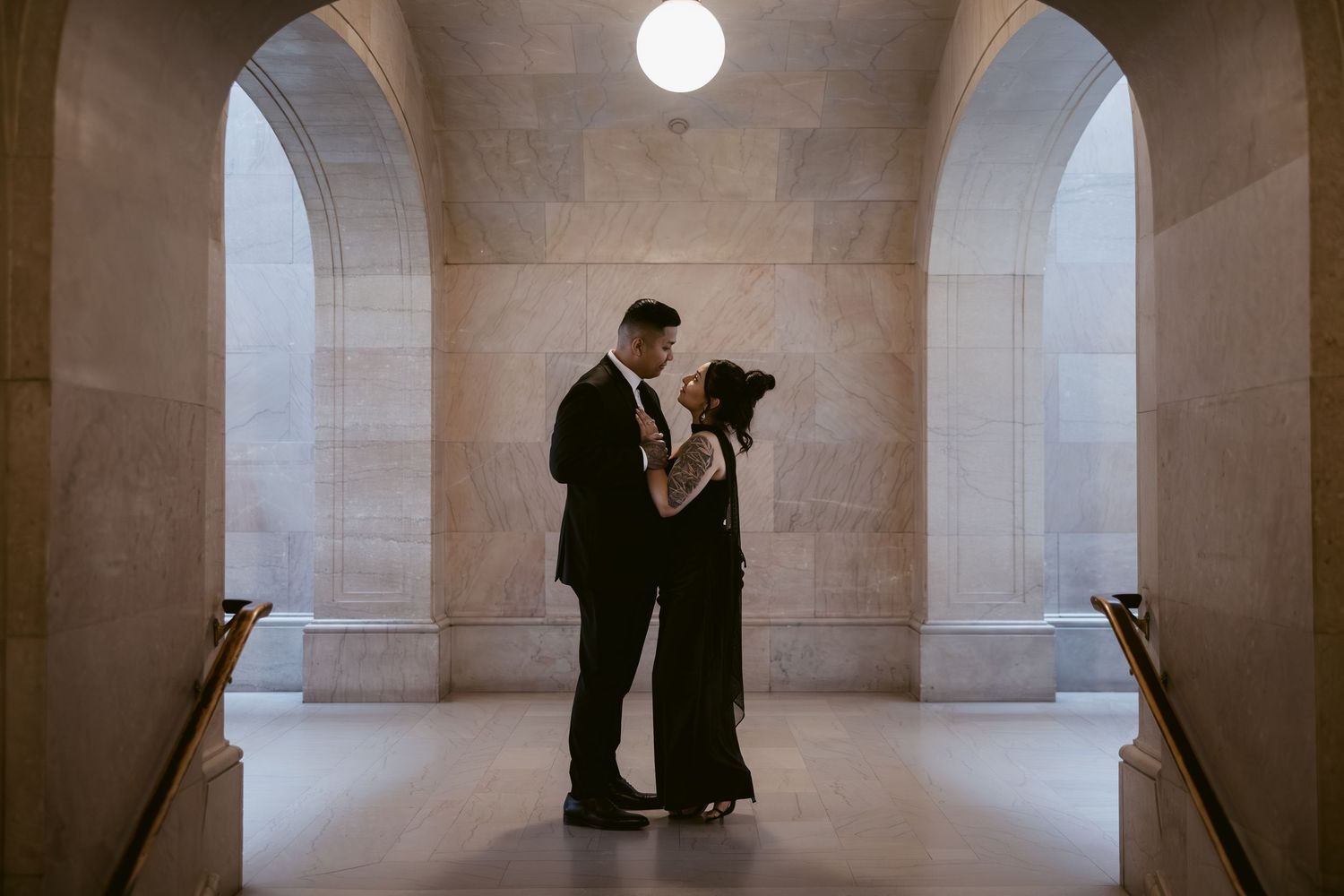 Elegant architectural hallway with stone columns and dramatic lighting creates moody atmosphere.