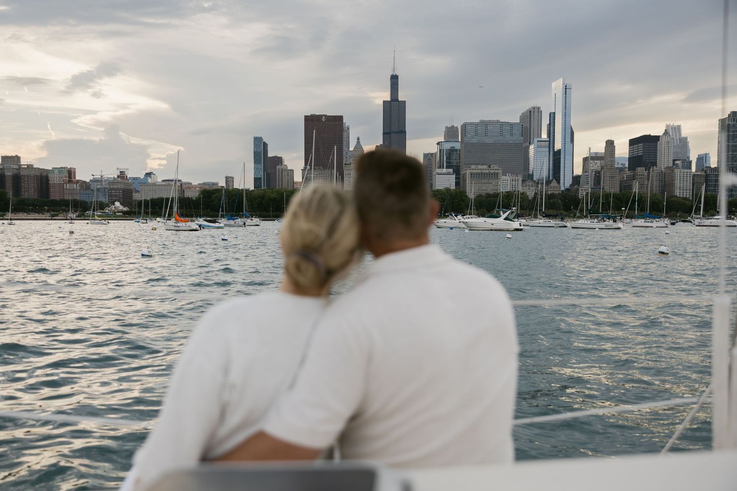 Panoramic view of Chicago's skyline across Lake Michigan during a cloudy evening.