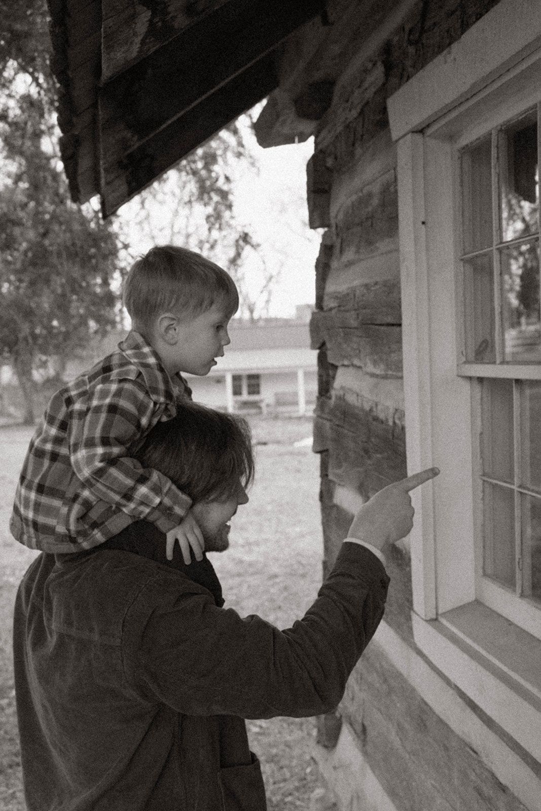 LIFESTYLE FATHER AND SON PHOTO CANDID POINTING INTO A CABIN