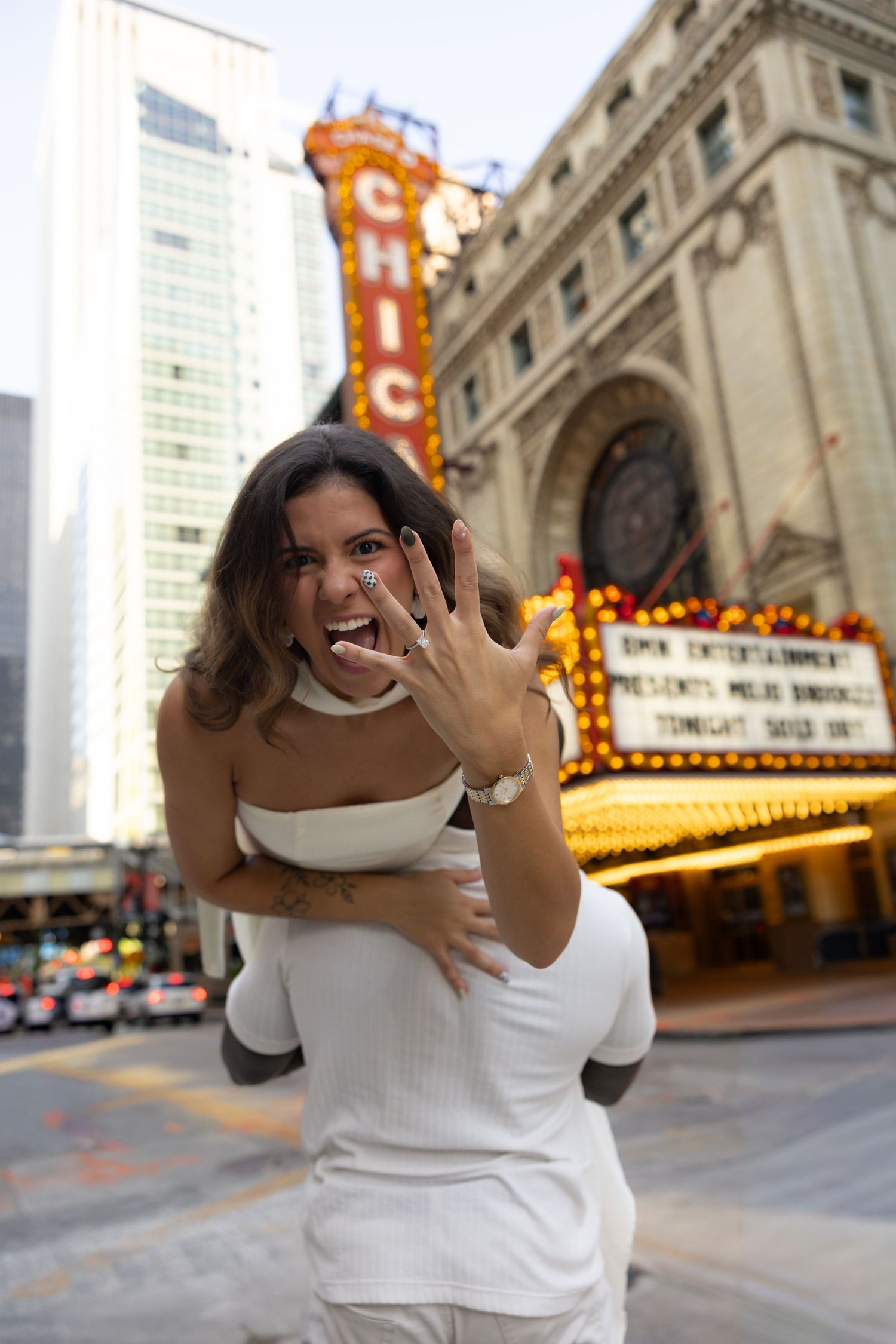 A joyful moment captured in front of the illuminated Chicago Theatre marquee downtown.