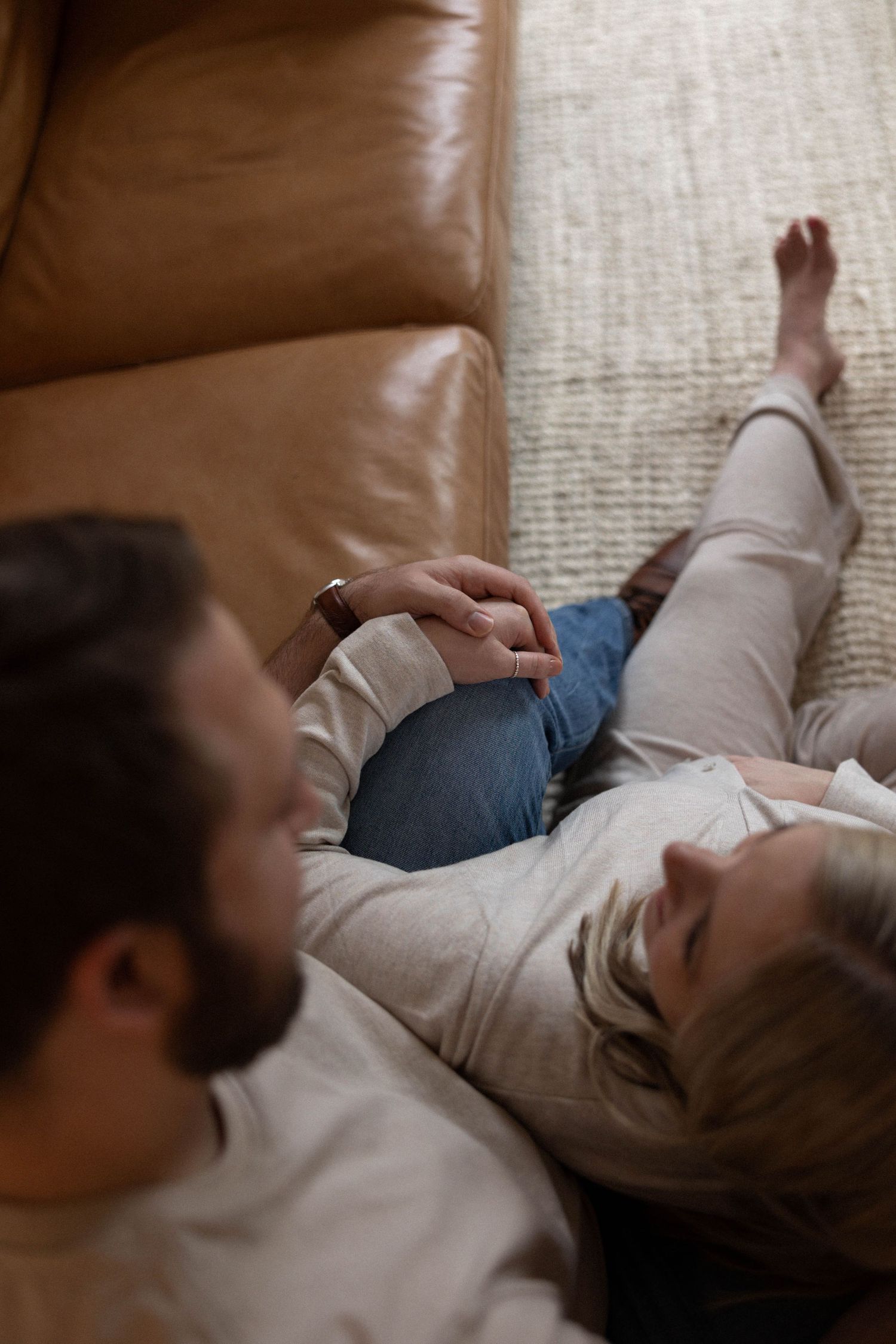 A cozy lifestyle moment shared on a leather couch with soft lighting and relaxed poses.