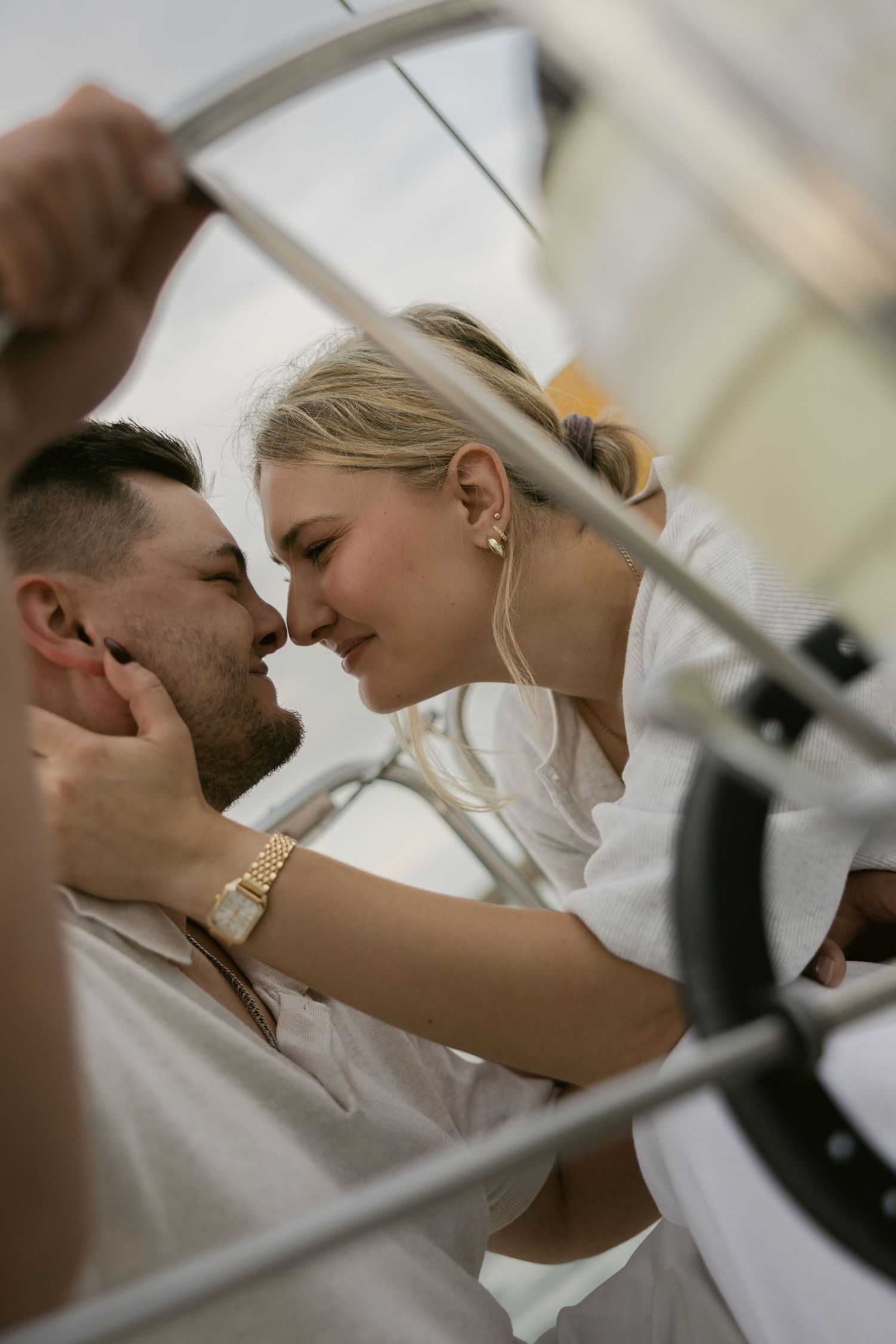 Tender moment shared between a couple dressed in white during their sailboat photoshoot.