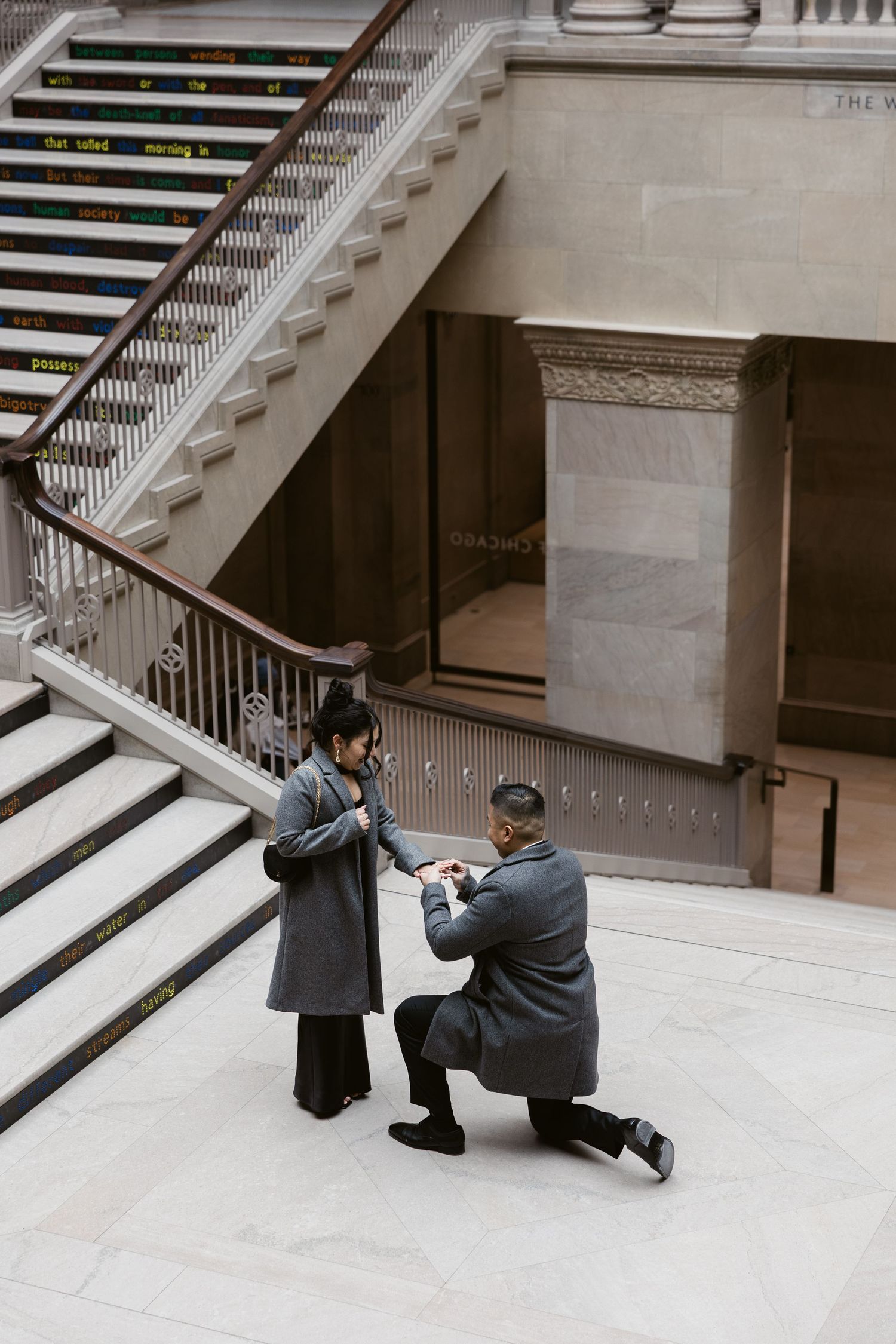 A photography session takes place on grand marble stairs in a classical building.