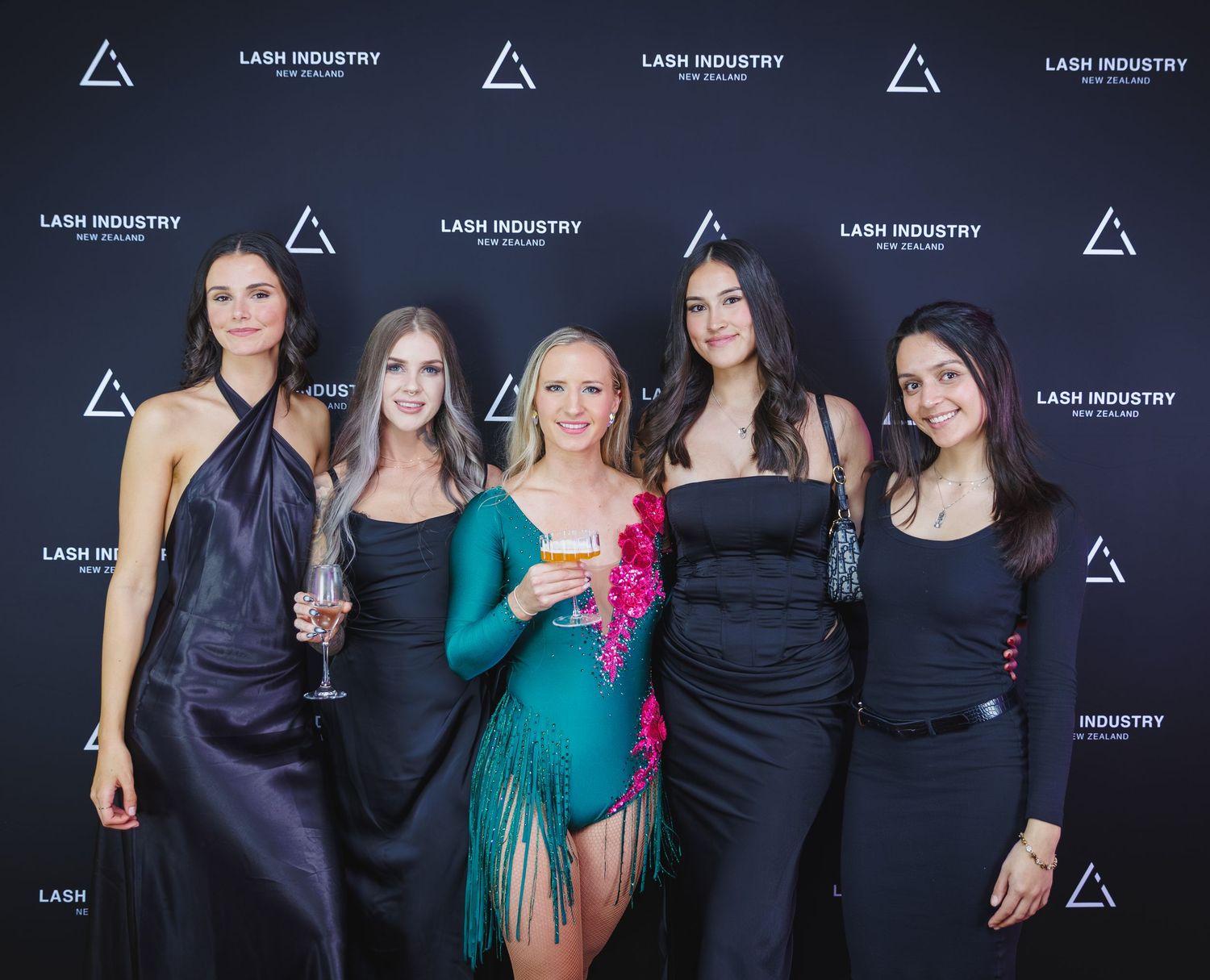 Five women posing in front of Lash Industry New Zealand branded backdrop at awards event.