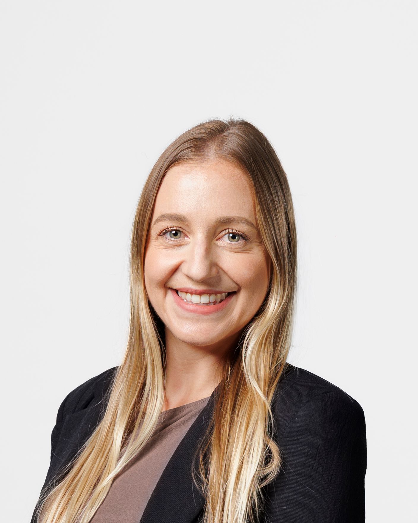 Professional headshot of a smiling young woman with long blonde hair wearing a black blazer.