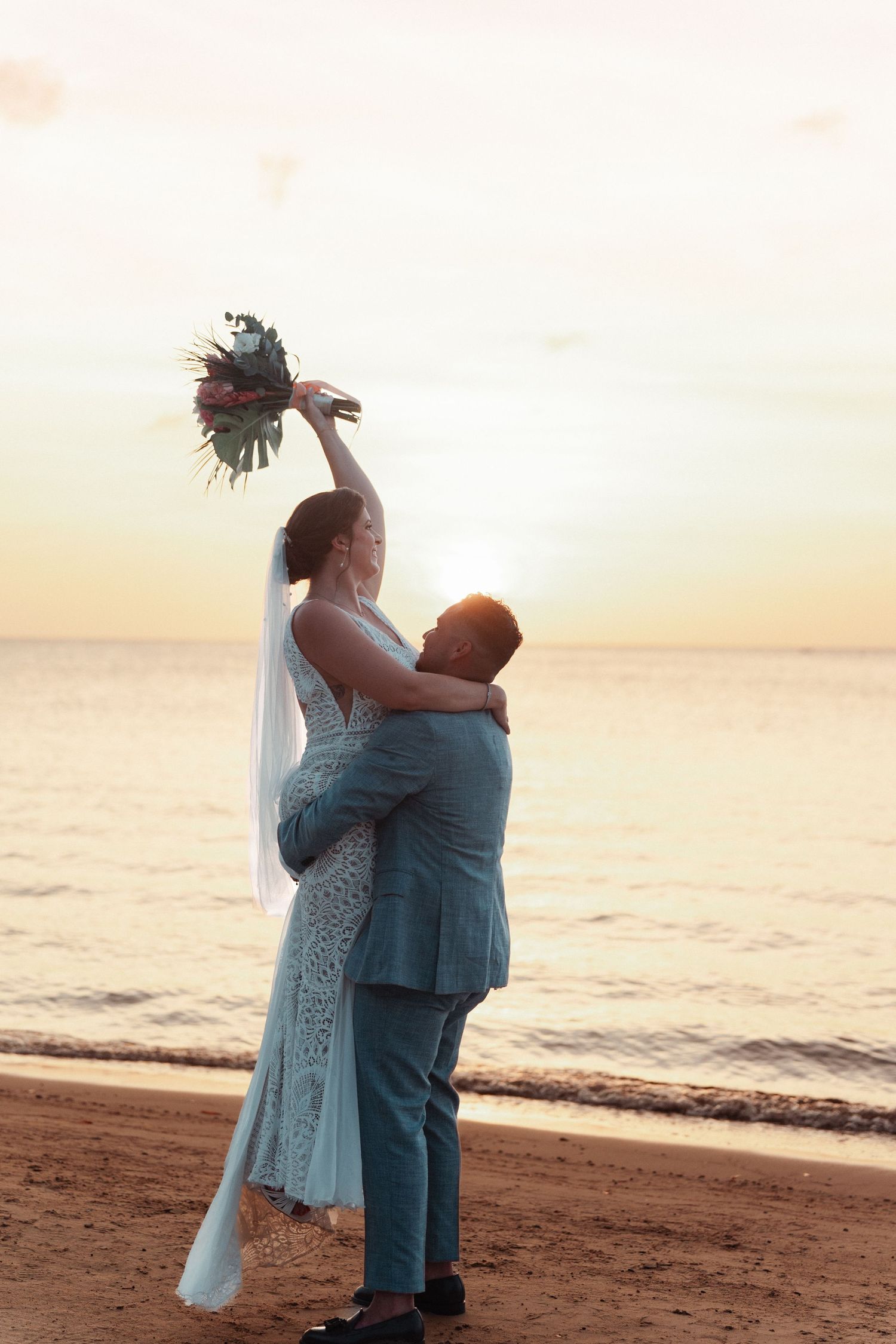 Novios caminando en la playa al atardecer / Couple walking on the beach at sunset