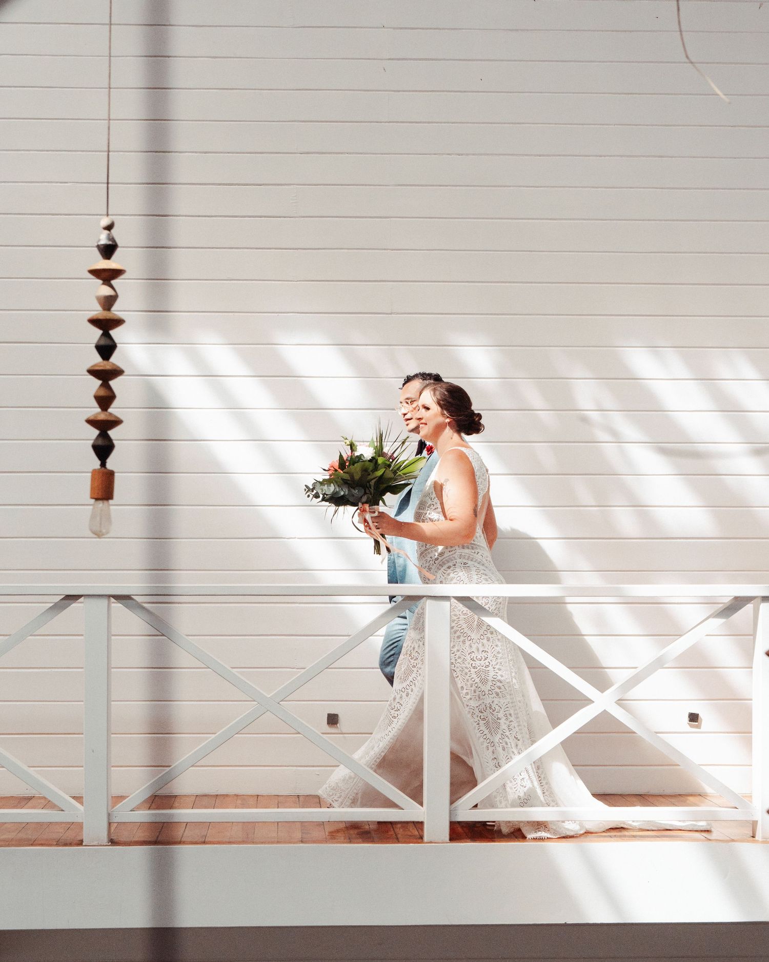 Novia con ramo en balcón blanco de madera / Bride with bouquet on white wooden balcony