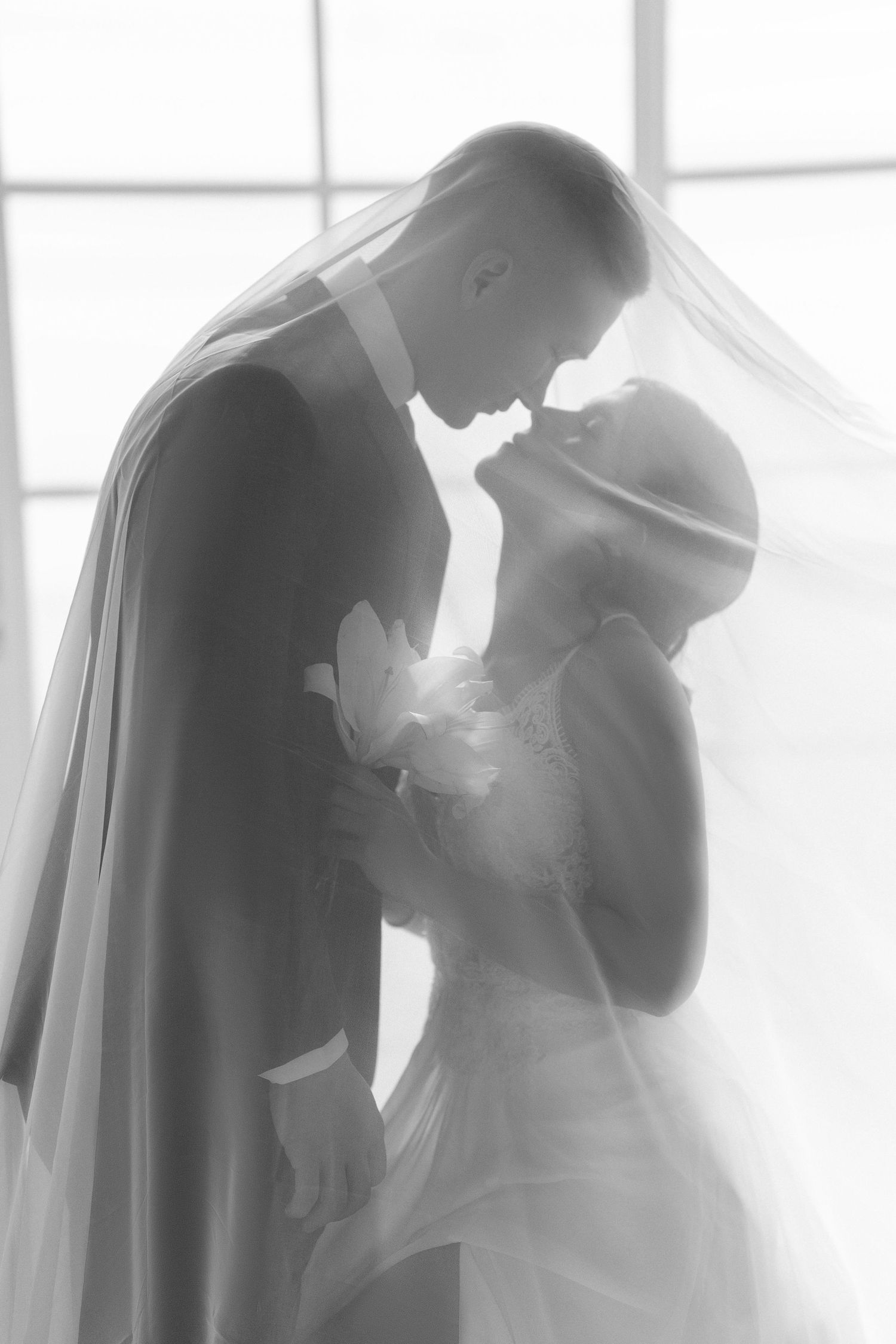 Pareja abrazada frente a ventana con luz suave / Couple hugging by soft-lit window