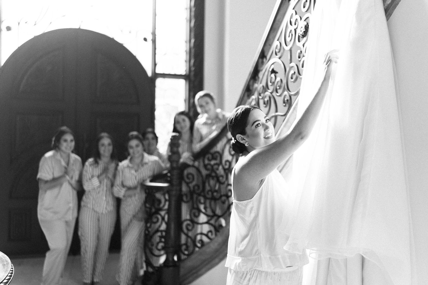 Novia sonriendo con sus damas levantando el velo / Bride smiling as bridesmaids lift her veil