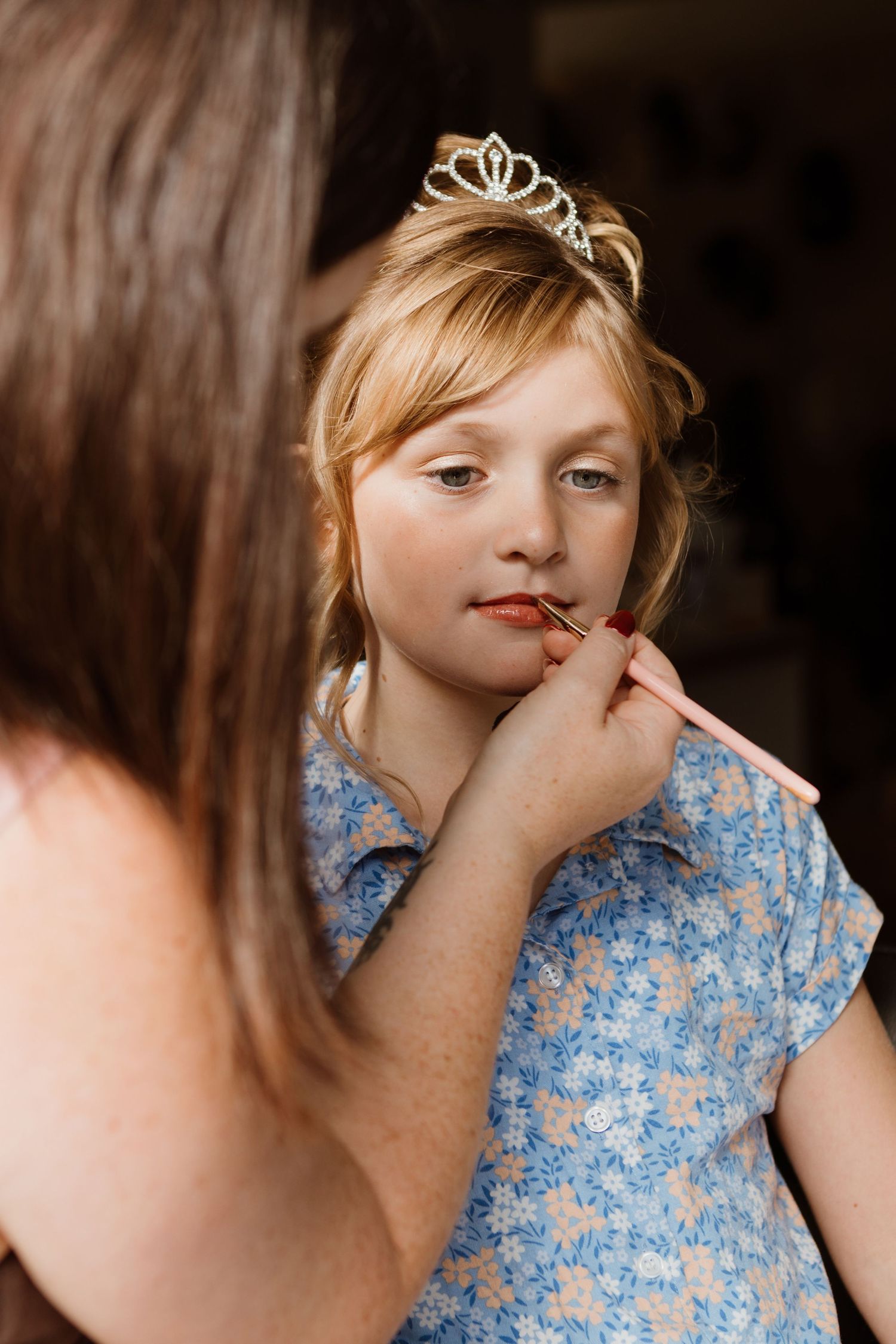 Sequence of images showing makeup being applied to someone wearing a blue floral dress and tiara.