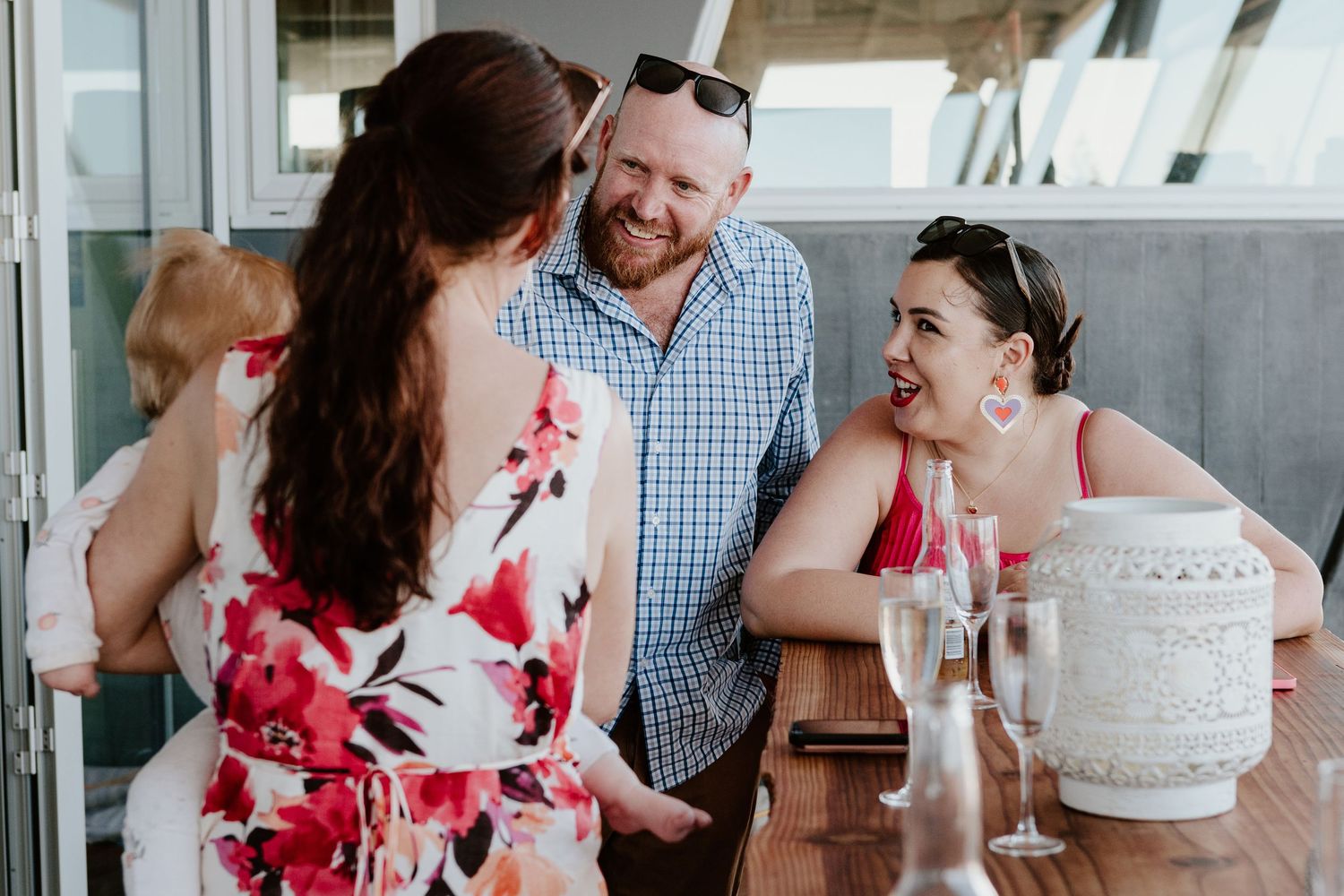 Wedding reception guests celebrating around a white wedding cake.