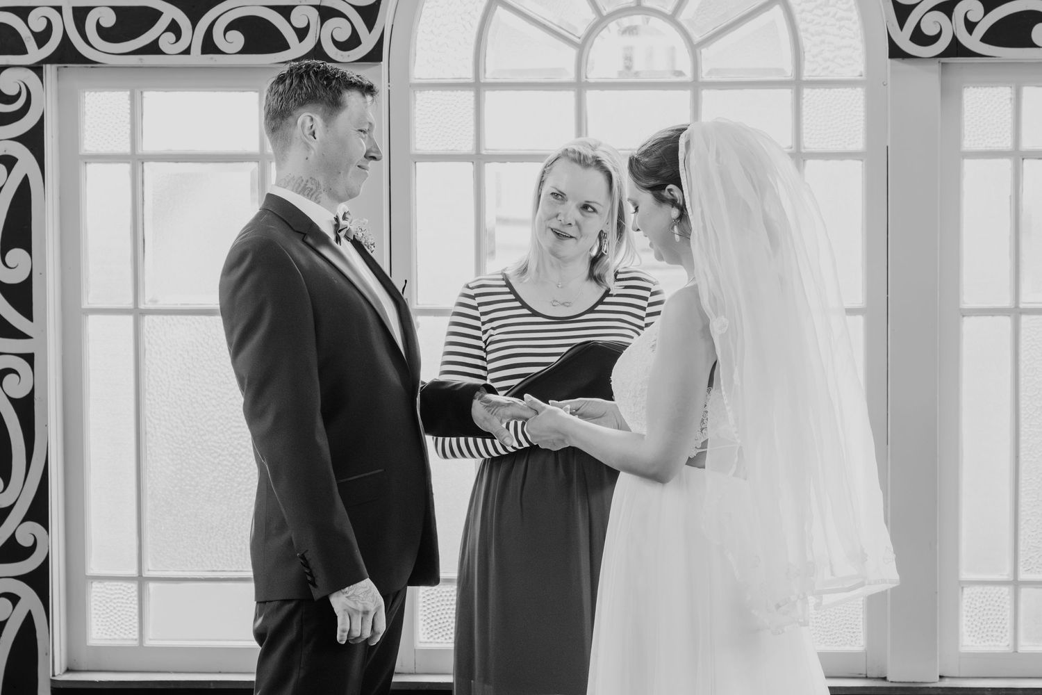 A wedding ceremony scene with striking architectural details and natural light streaming through windows.