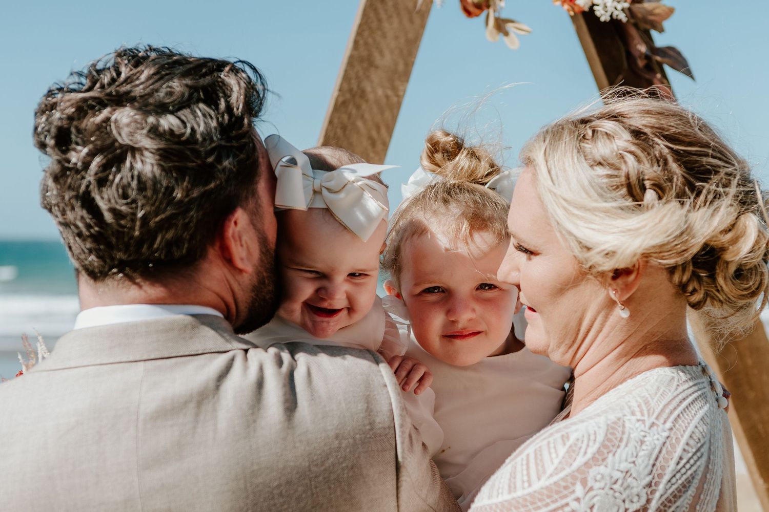 A romantic beach wedding ceremony shows an intimate moment between the couple during an outdoor celebration.