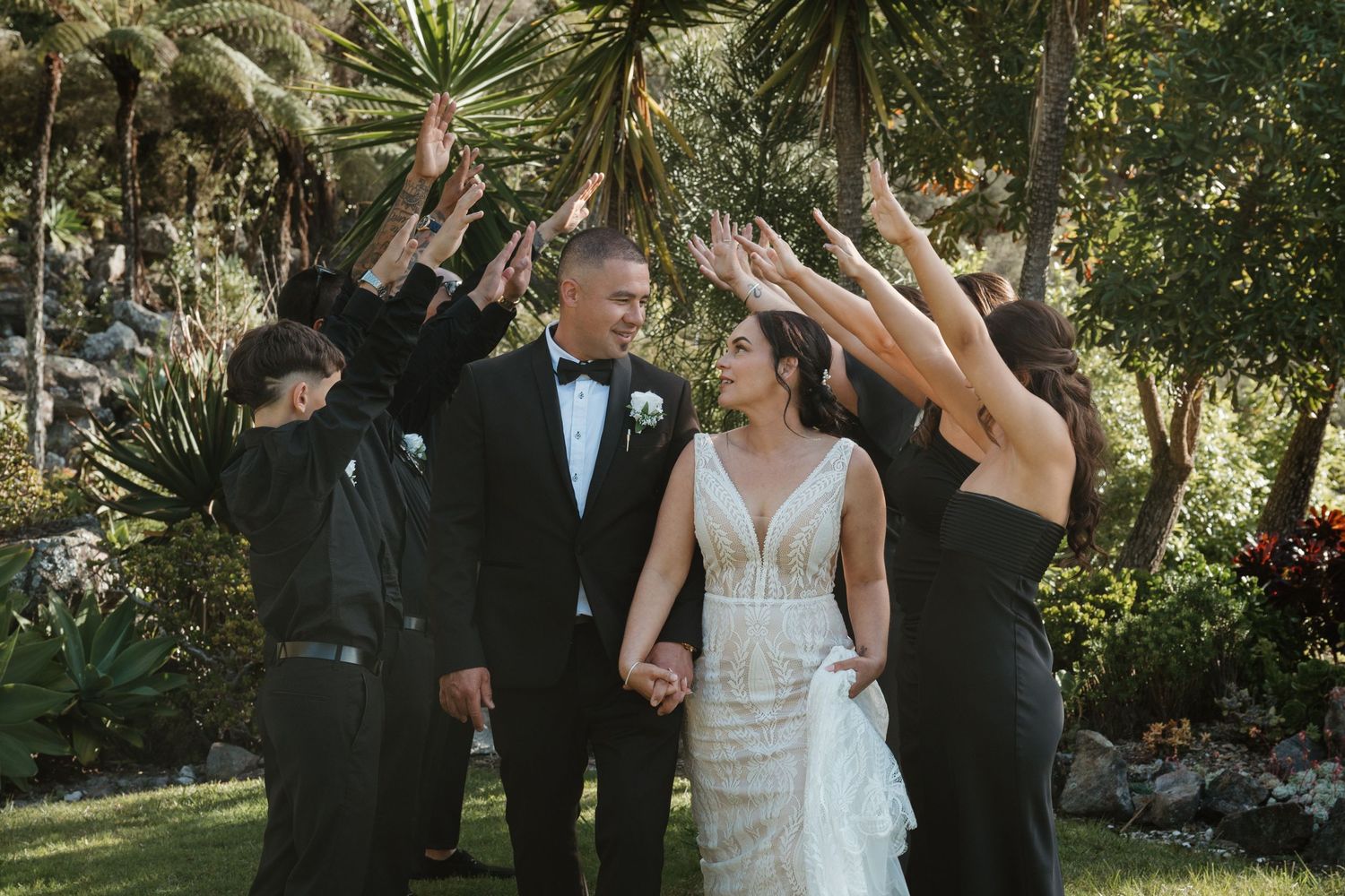 A couple dances together during their outdoor garden wedding celebration while guests watch and smile.